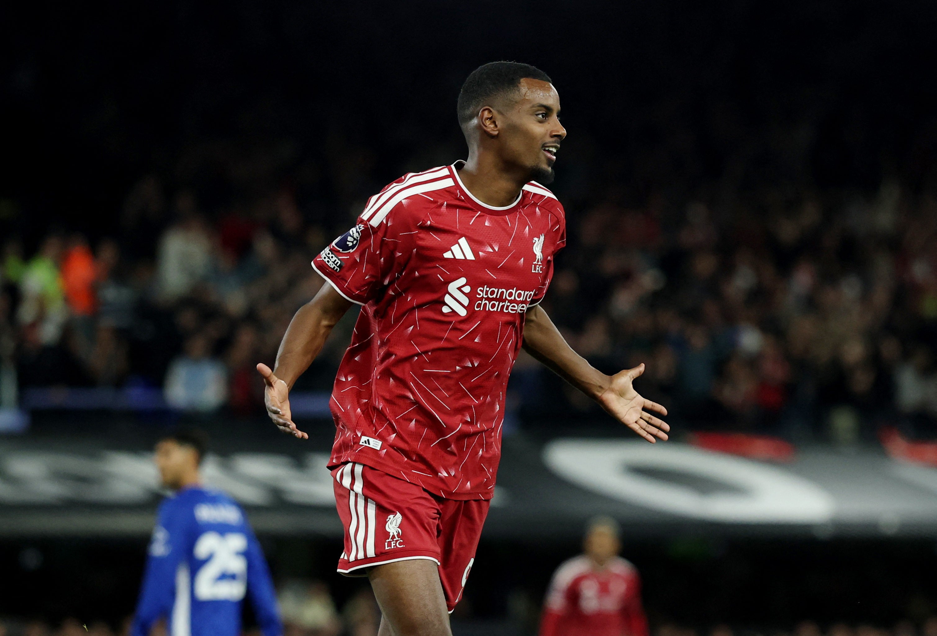 En fotbollsspelare i Liverpools röda tröja firar under en match.