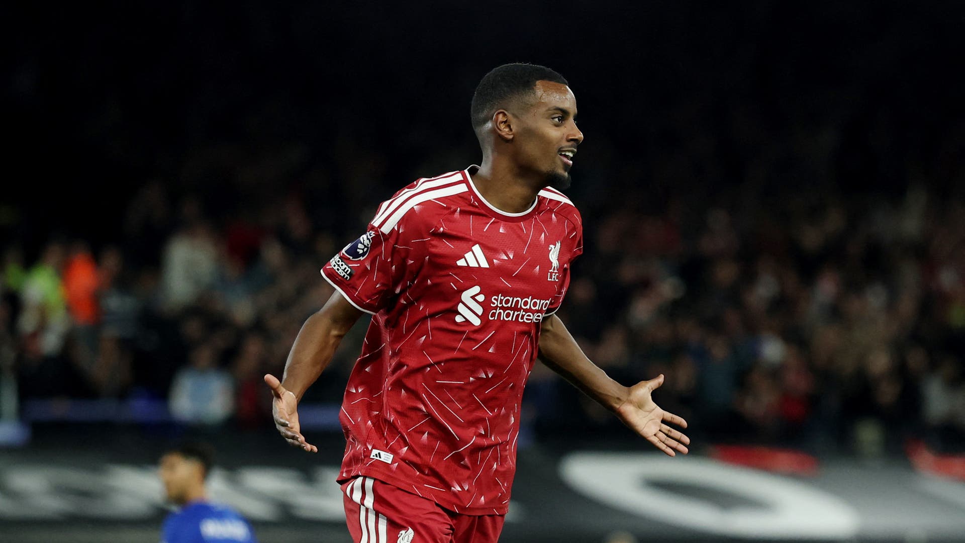 En fotbollsspelare i Liverpools röda tröja firar under en match.