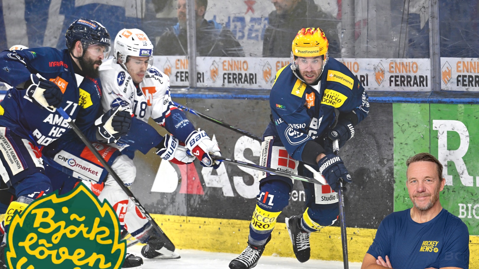 Ishockeymatch med spelare i mörkblå och vita tröjor som kämpar om pucken vid sargen. Björklöven-logotyp syns i nedre vänstra hörnet.