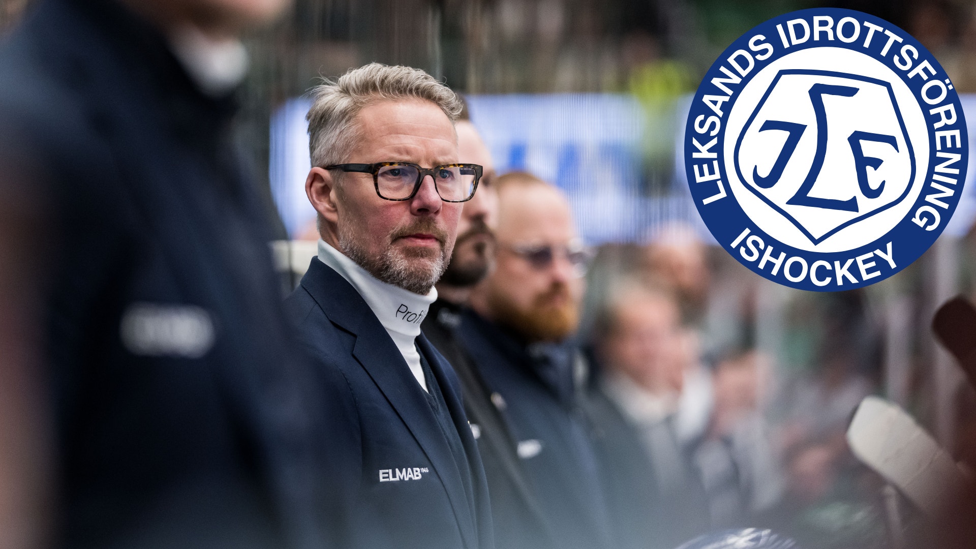 En tränare i kostym står vid sargen under en ishockeymatch, med Leksands IF:s logotyp infälld i bilden.