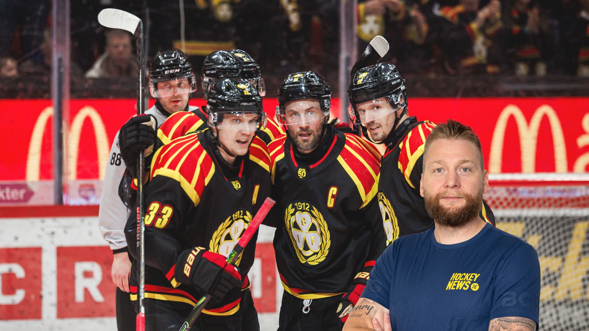 Fyra ishockeyspelare i svart och röd/gul utrustning står på isen tillsammans med en man i mörkblå t-shirt som poserar framför dem. En av spelarna håller en hockeyklubba.
