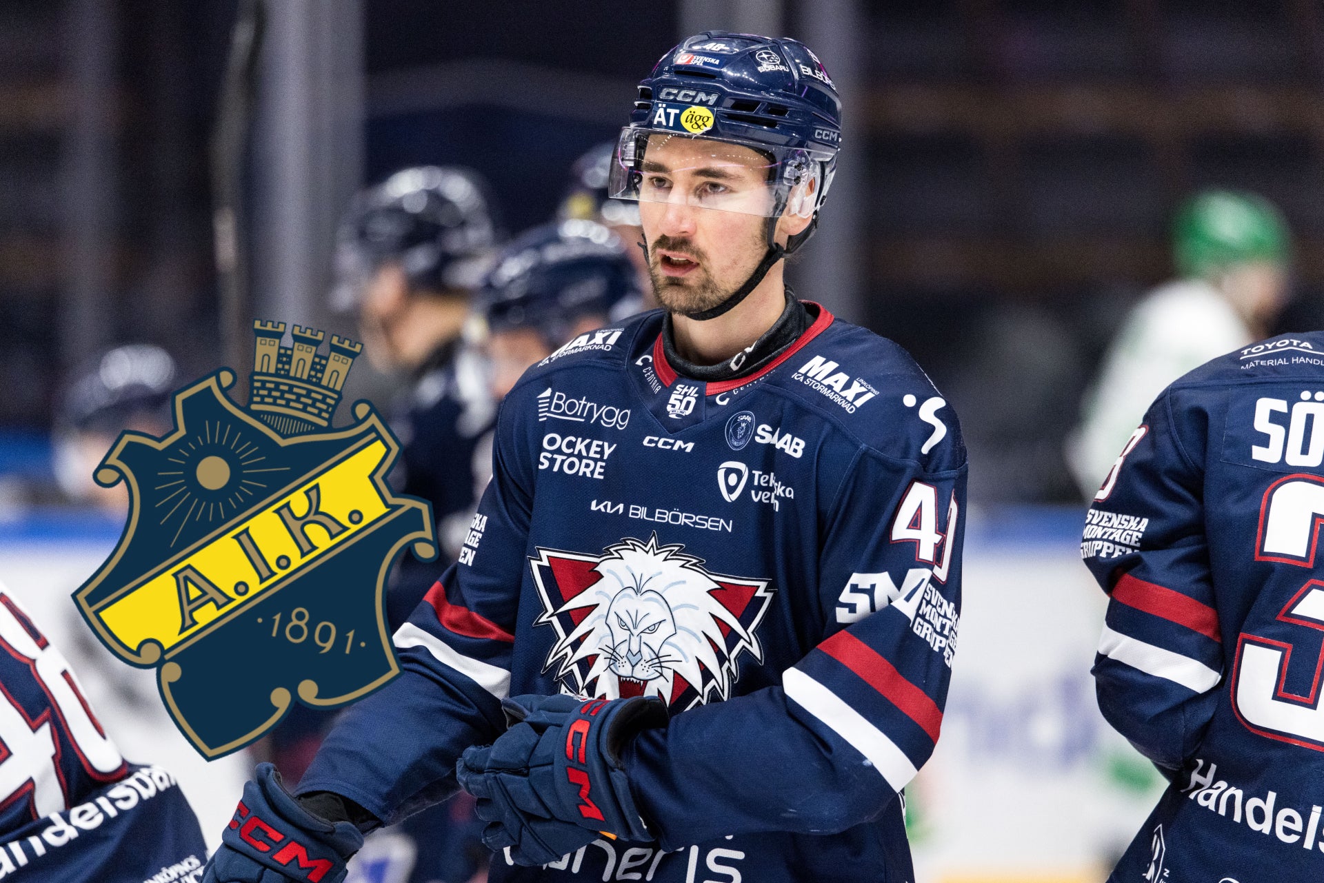 Ishockeyspelare i mörkblå matchdräkt under en ishockeymatch. Spelaren bär hjälm och är fokuserad på spelet med andra spelare synliga i bakgrunden.