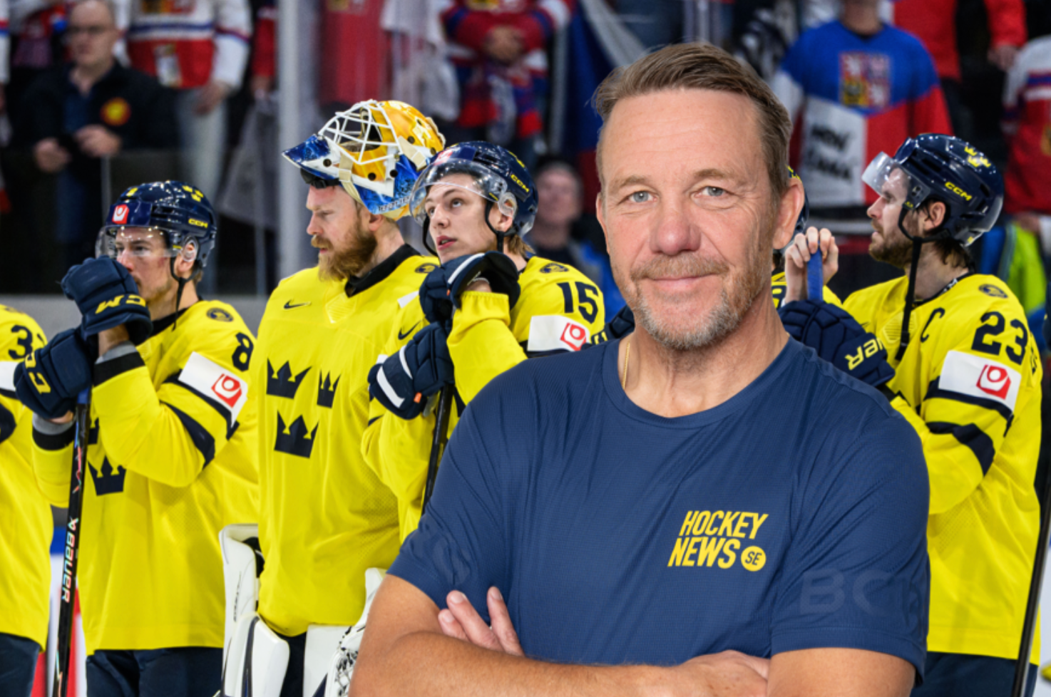 Porträtt av en man i mörkblå t-shirt med Hockey News-logga framför ett ishockeylag i gula tröjor.