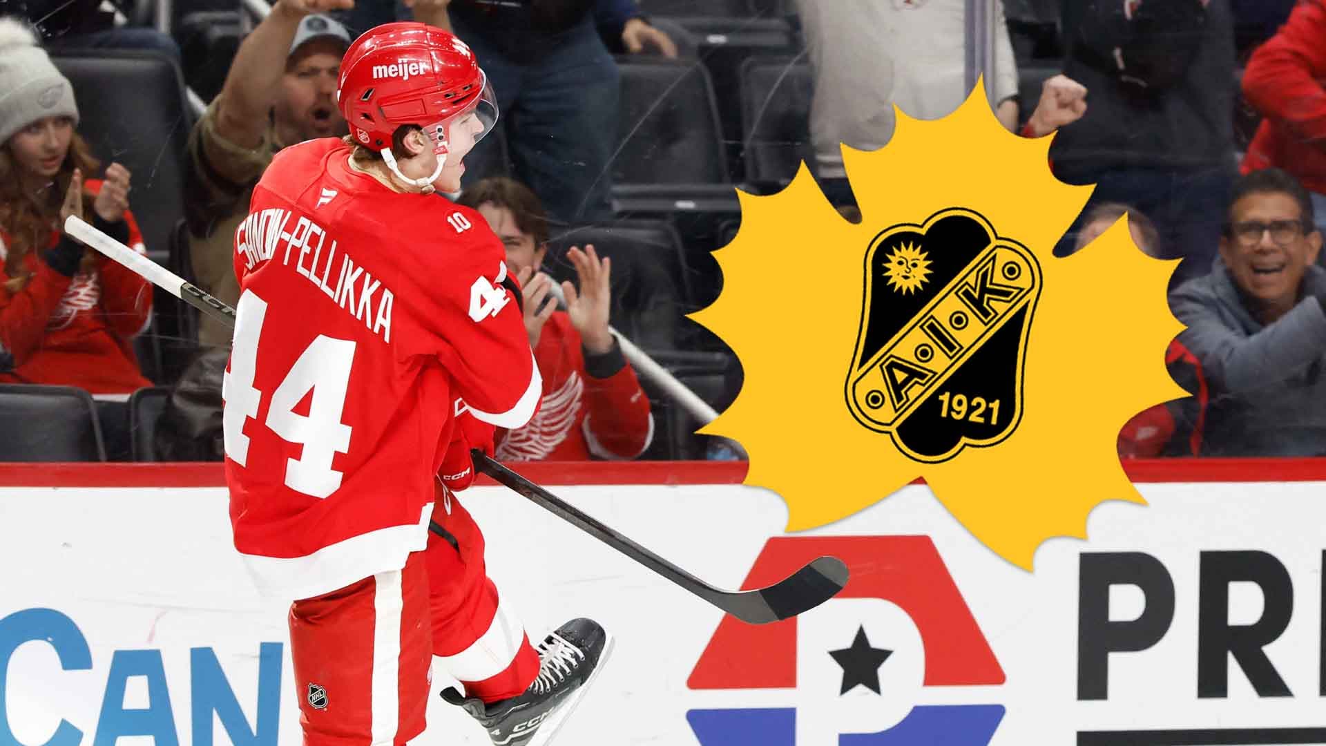 Ishockeyspelare i röd tröja firar ett mål med armarna i luften.