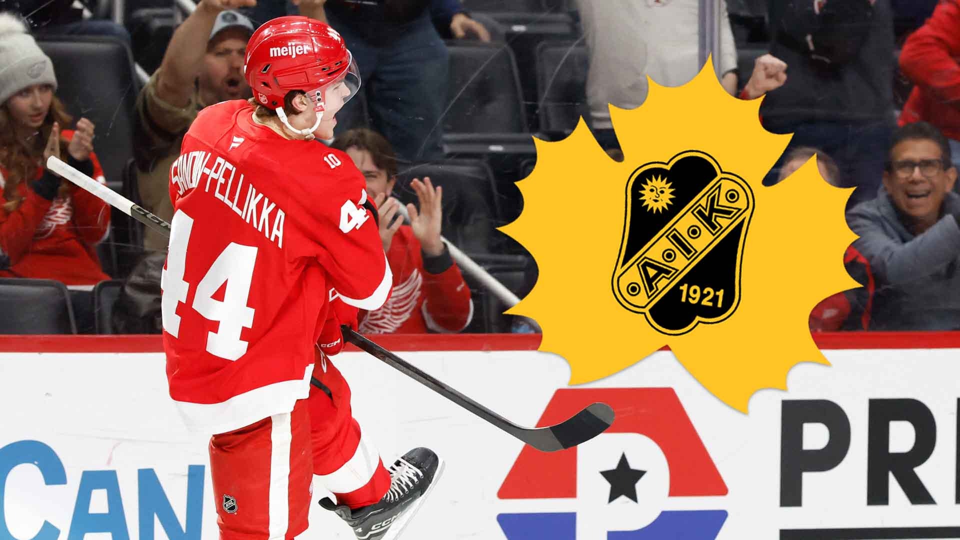 Ishockeyspelare i röd tröja firar ett mål med armarna i luften.