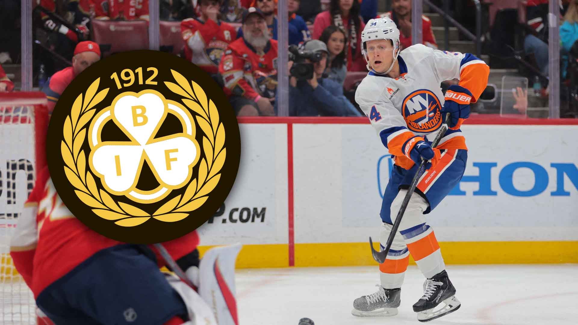 Ishockeyspelare i blå och orange uniform spelar under en match i en fullsatt arena.