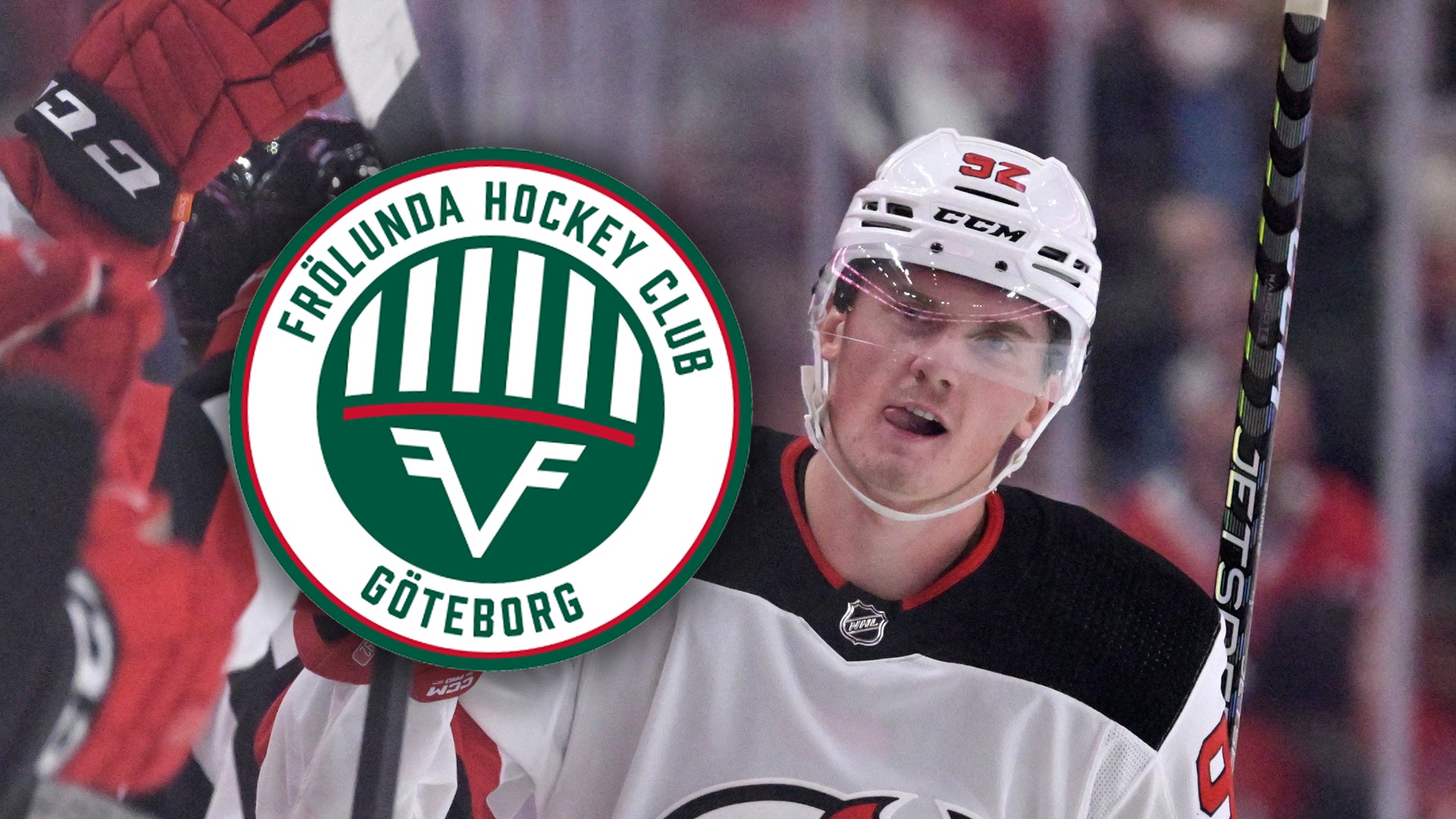 Ishockeyspelare i vit och röd tröja med hjälm håller en hockeyklubb. Frölunda Hockey Clubs logga syns i bakgrunden.