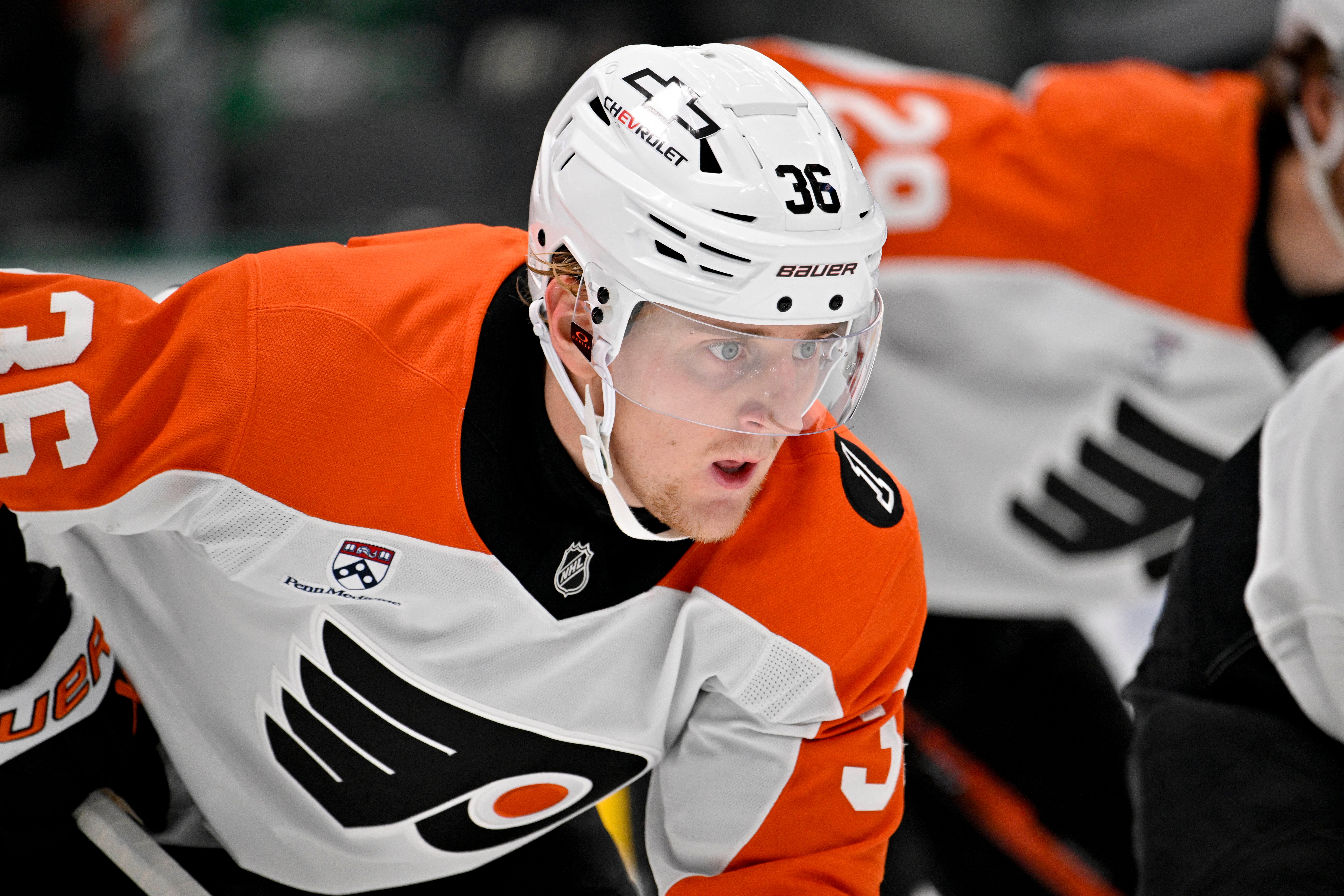 Ishockeyspelare i orange och vit tröja med nummer 36 och vit hjälm under en match.