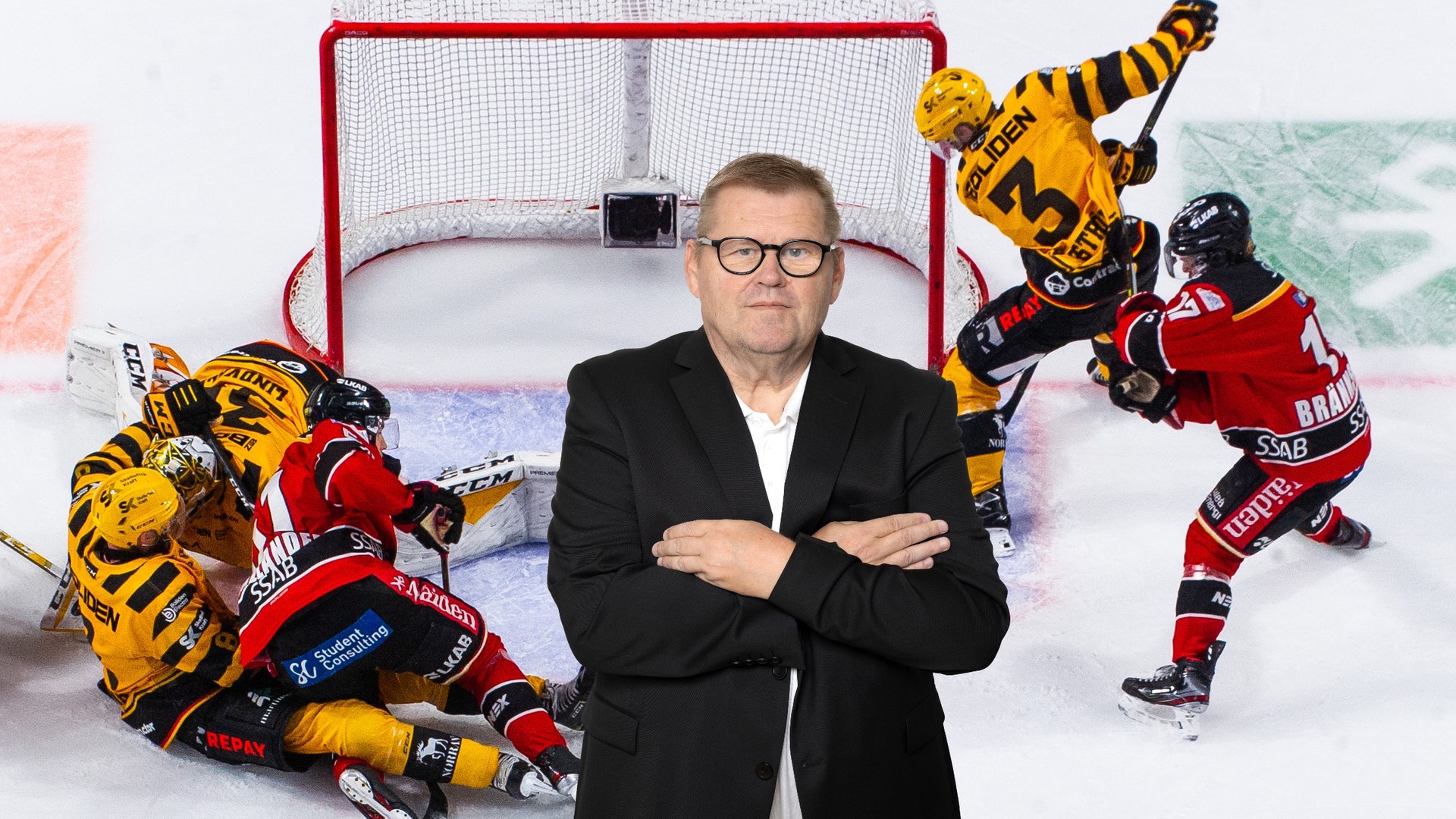 Man i svart kostym och glasögon står framför ett ishockeymål med ishockeyspelare i gula och röda uniformer omkring honom.