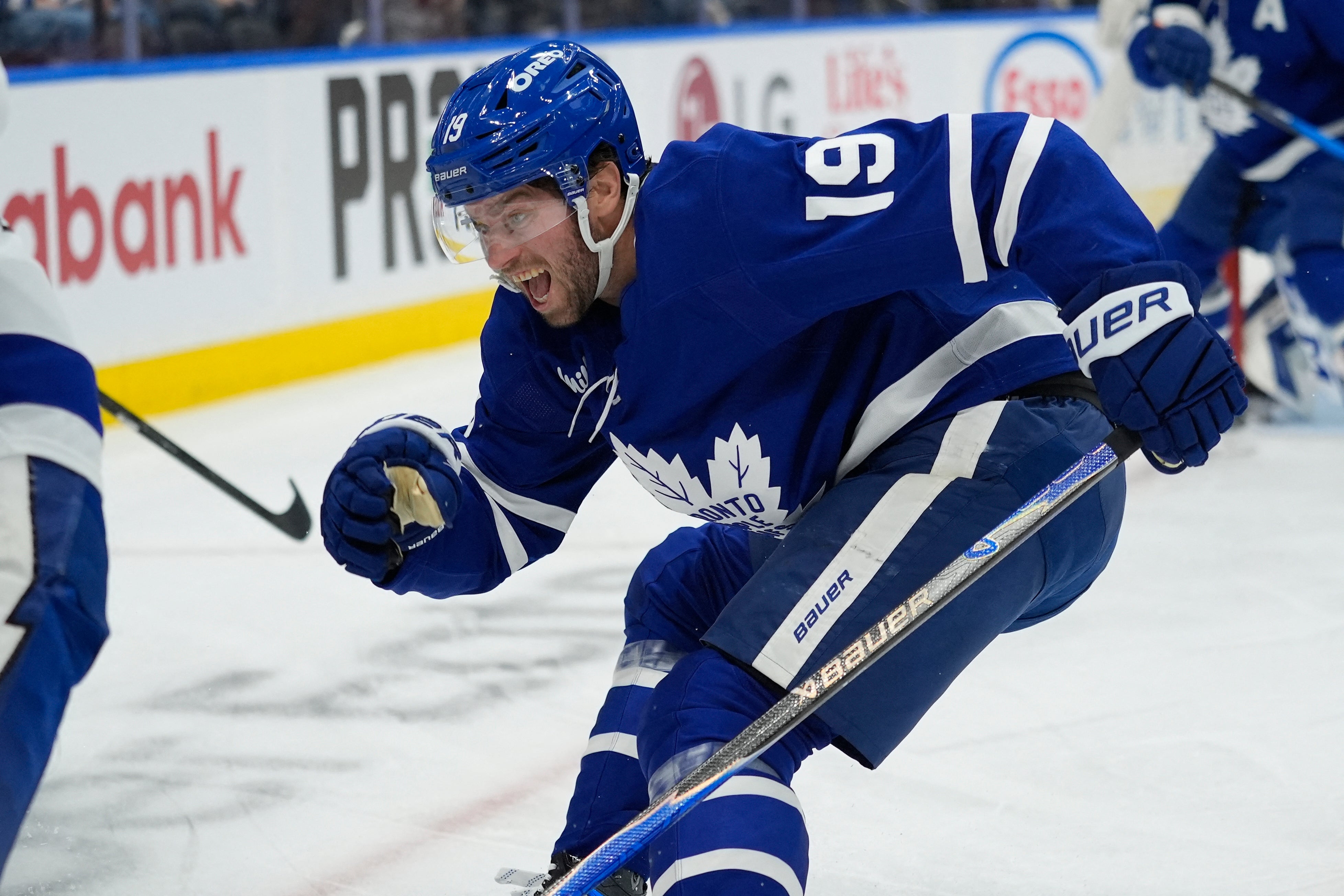 Ishockeyspelare i blå Toronto Maple Leafs-uniform spelar på isen under en match.