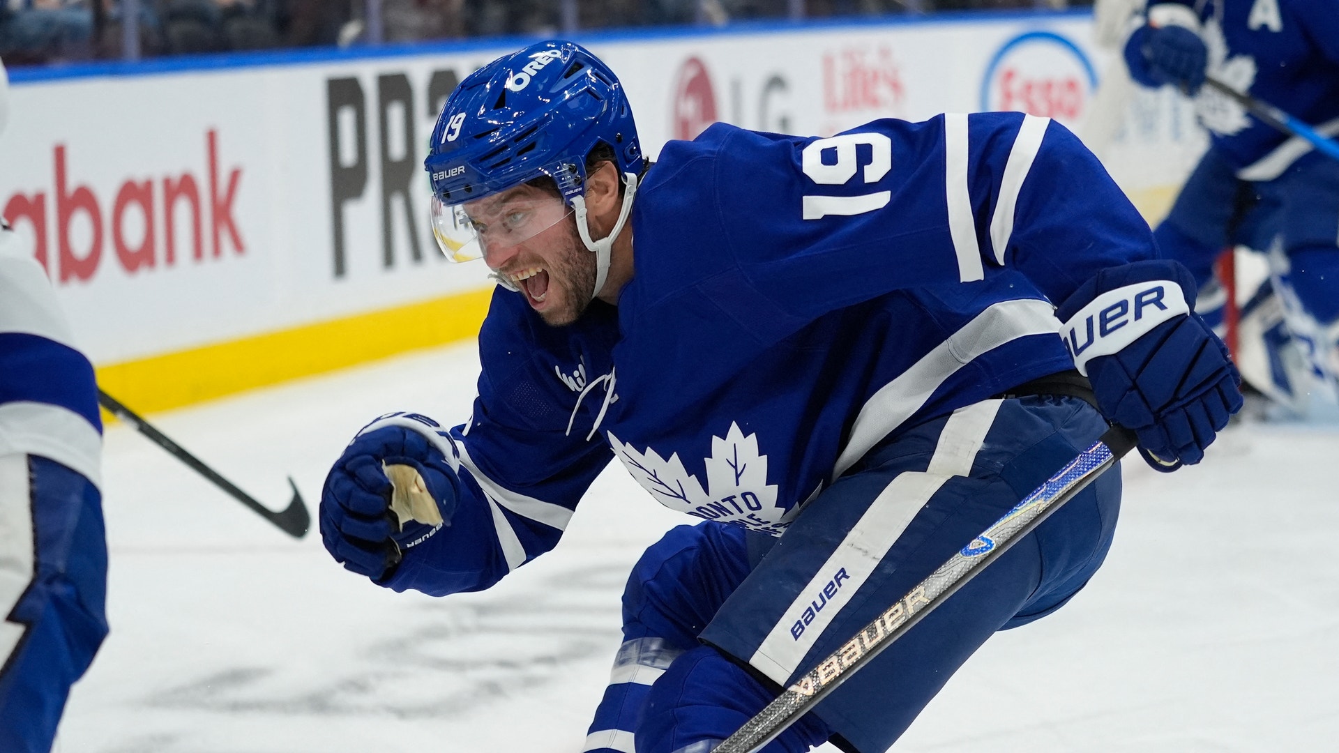 Ishockeyspelare i blå Toronto Maple Leafs-uniform spelar på isen under en match.