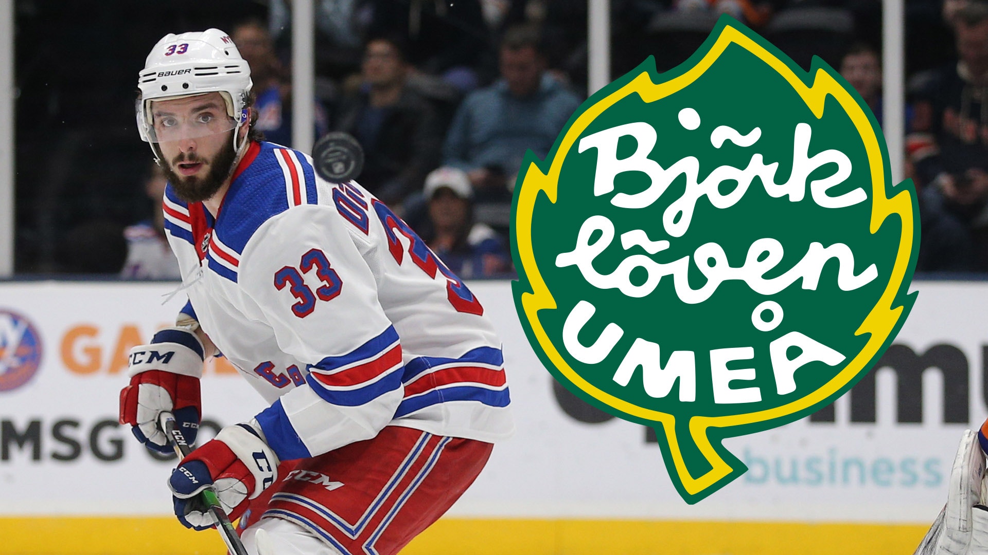 Ishockeyspelare i vit tröja med blå och röda ränder under match. Björklöven Umeå-logon syns i övre högra hörnet.