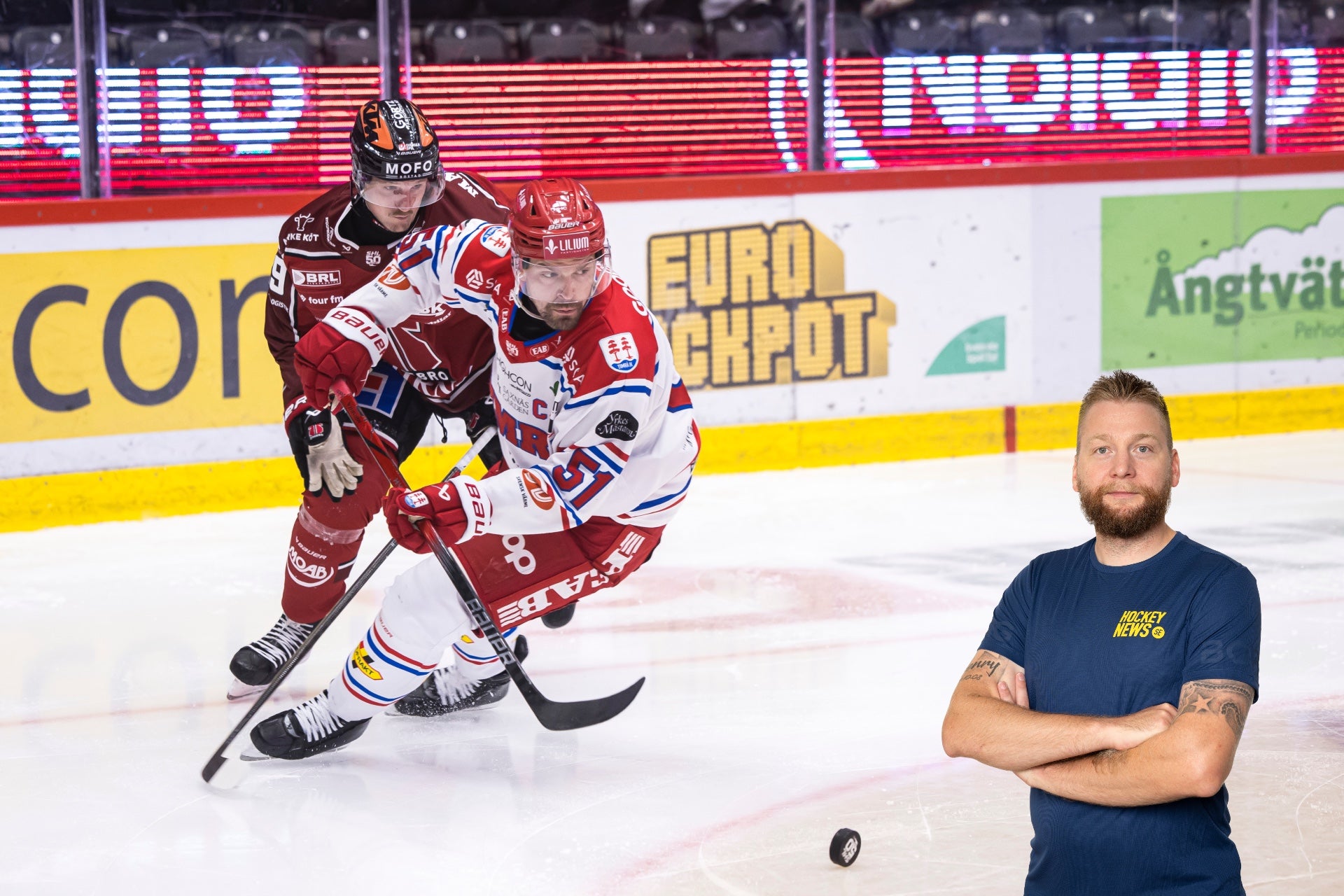 Ishockeymatch på en arena med en spelare i röd och vit tröja som spelar på isen. En man i mörk t-shirt står vid sidan av. I bakgrunden syns sponsorlogotyper och en amerikansk flagga på reklambanden.