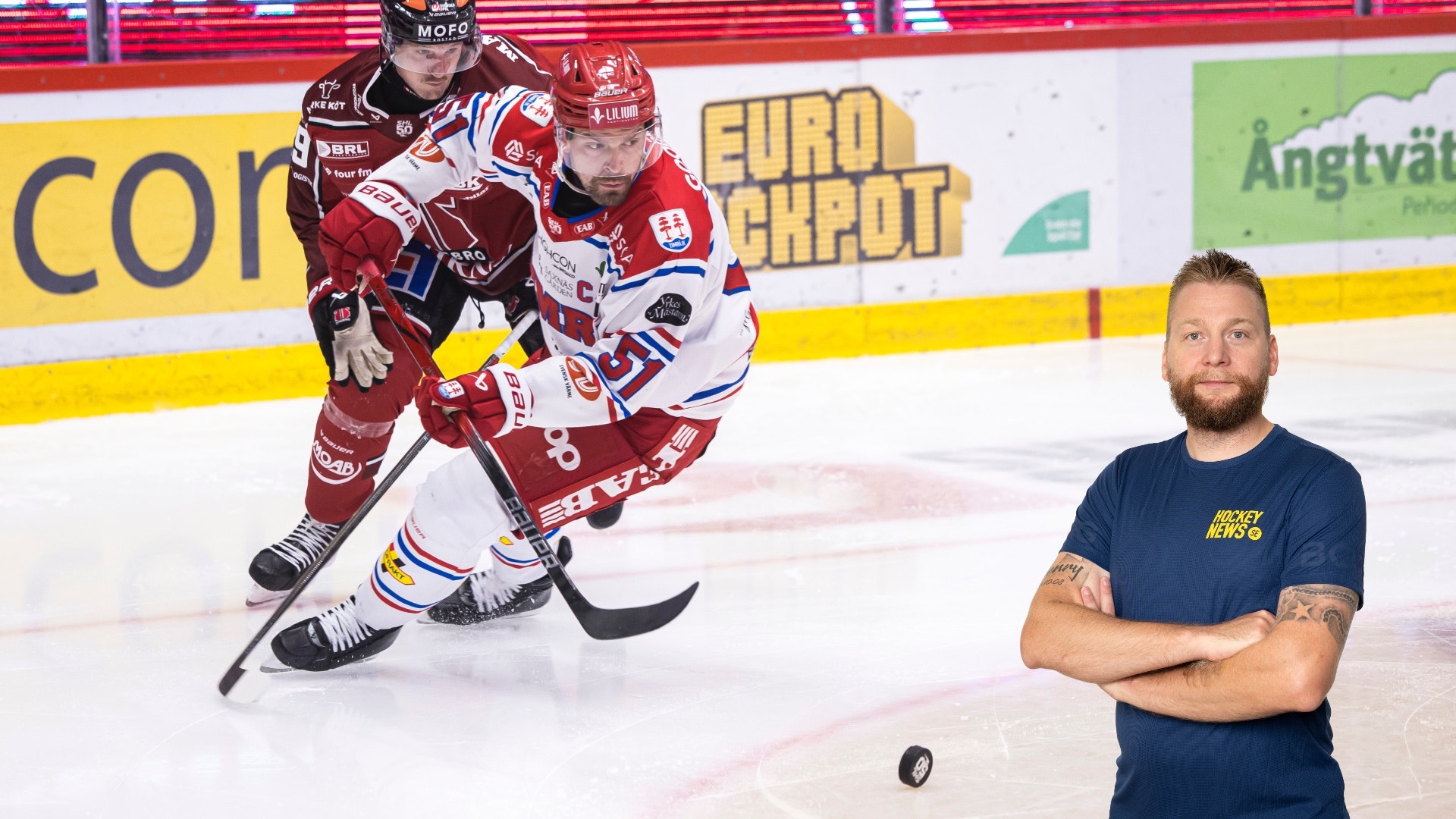 Ishockeymatch på en arena med en spelare i röd och vit tröja som spelar på isen. En man i mörk t-shirt står vid sidan av. I bakgrunden syns sponsorlogotyper och en amerikansk flagga på reklambanden.