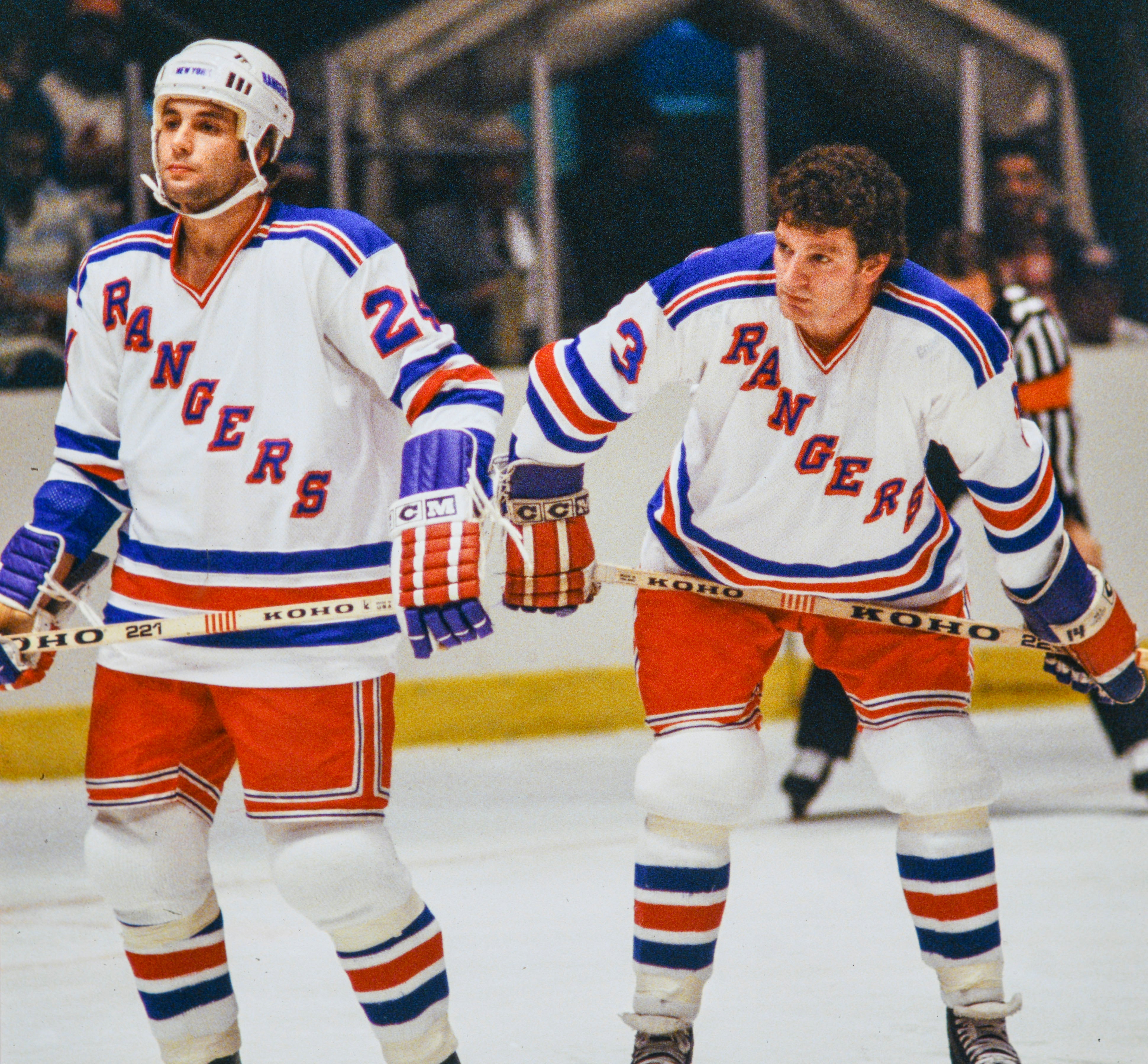 Två ishockeyspelare i New York Rangers-tröjor står på isen under en match.