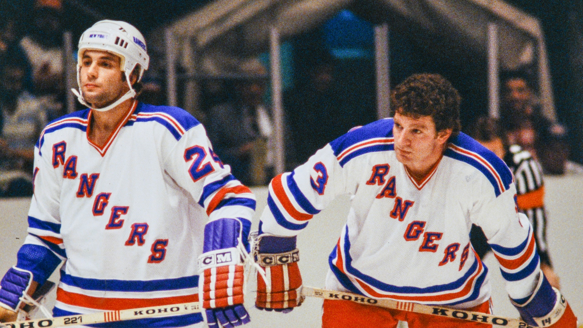 Två ishockeyspelare i New York Rangers-tröjor står på isen under en match.