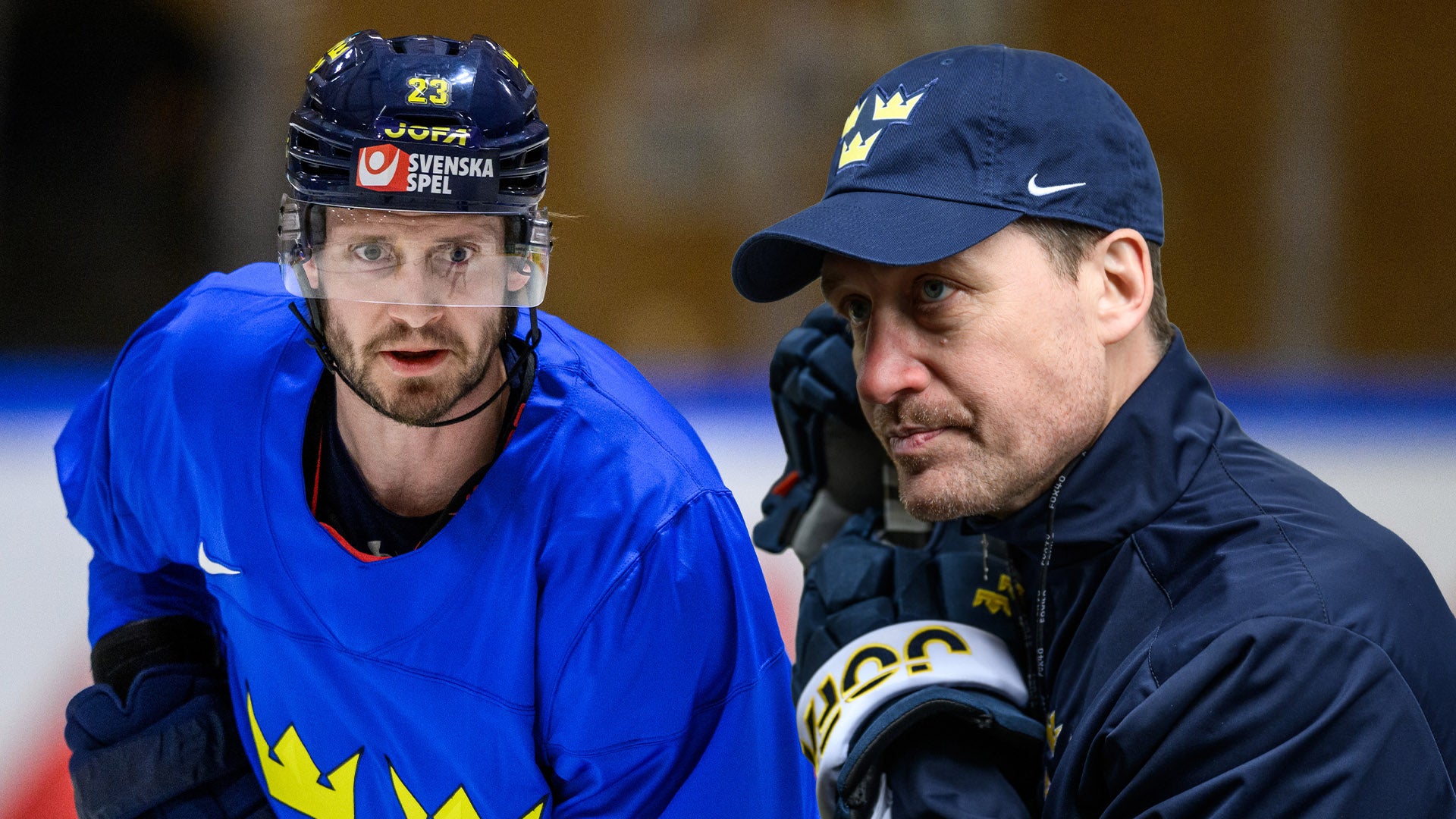 Ishockeyspelare i blå svensk landslagströja och hjälm sitter tillsammans med en tränare på bänken under en match.
