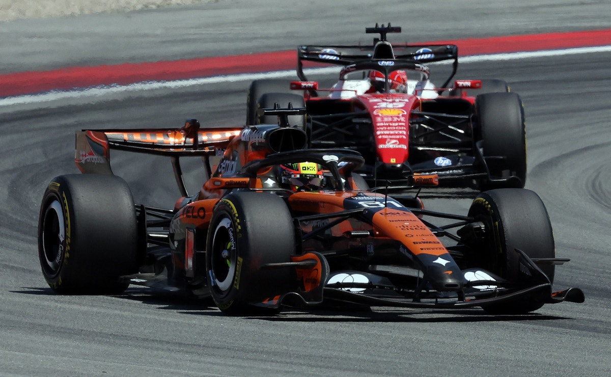 Två röda Ferrari-bilar kör på en racerbana under en Formel 1-tävling.