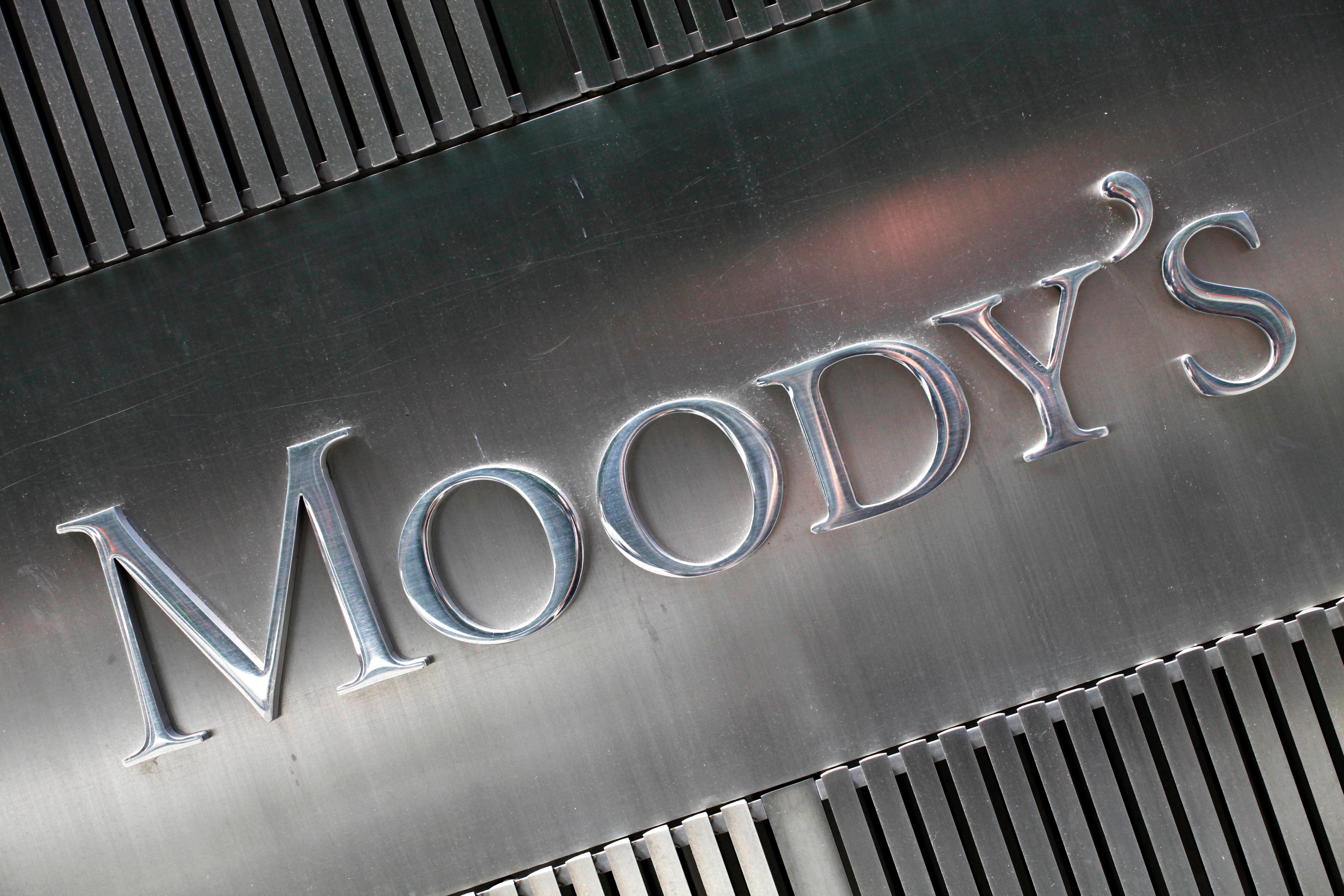 Metallisk skylt med texten Moody's präglad i silverfärgad metall, omgiven av vertikala metallribbor.