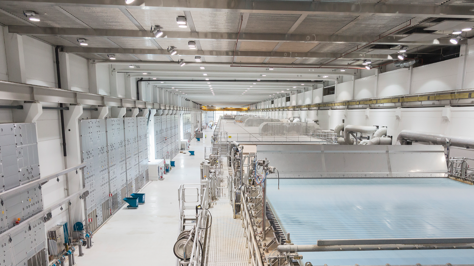 Industriell fabrik med stora produktskivor och tillverkningsutrustning i ett modernt lagerlokale