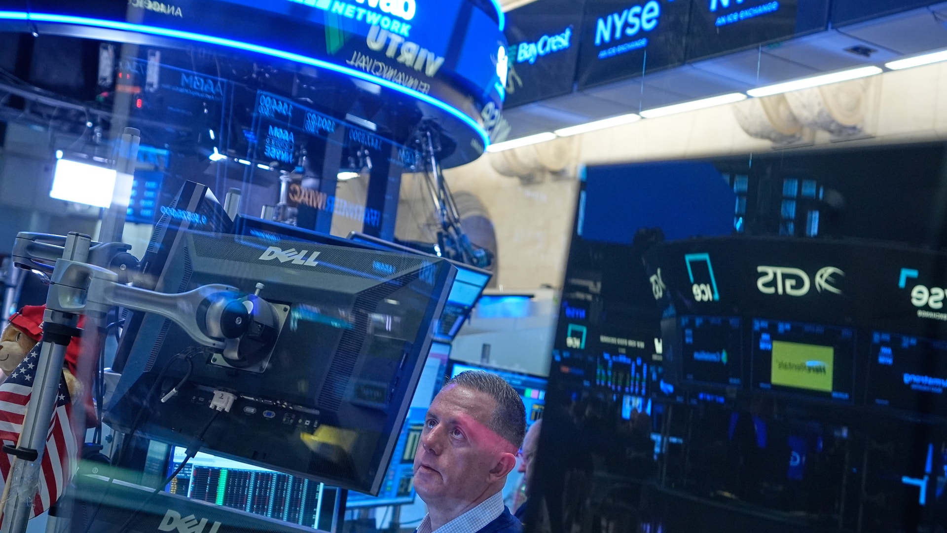 Handlare arbetar vid en handelsstationen på New York Stock Exchange med flera skärmar som visar marknadsdata.