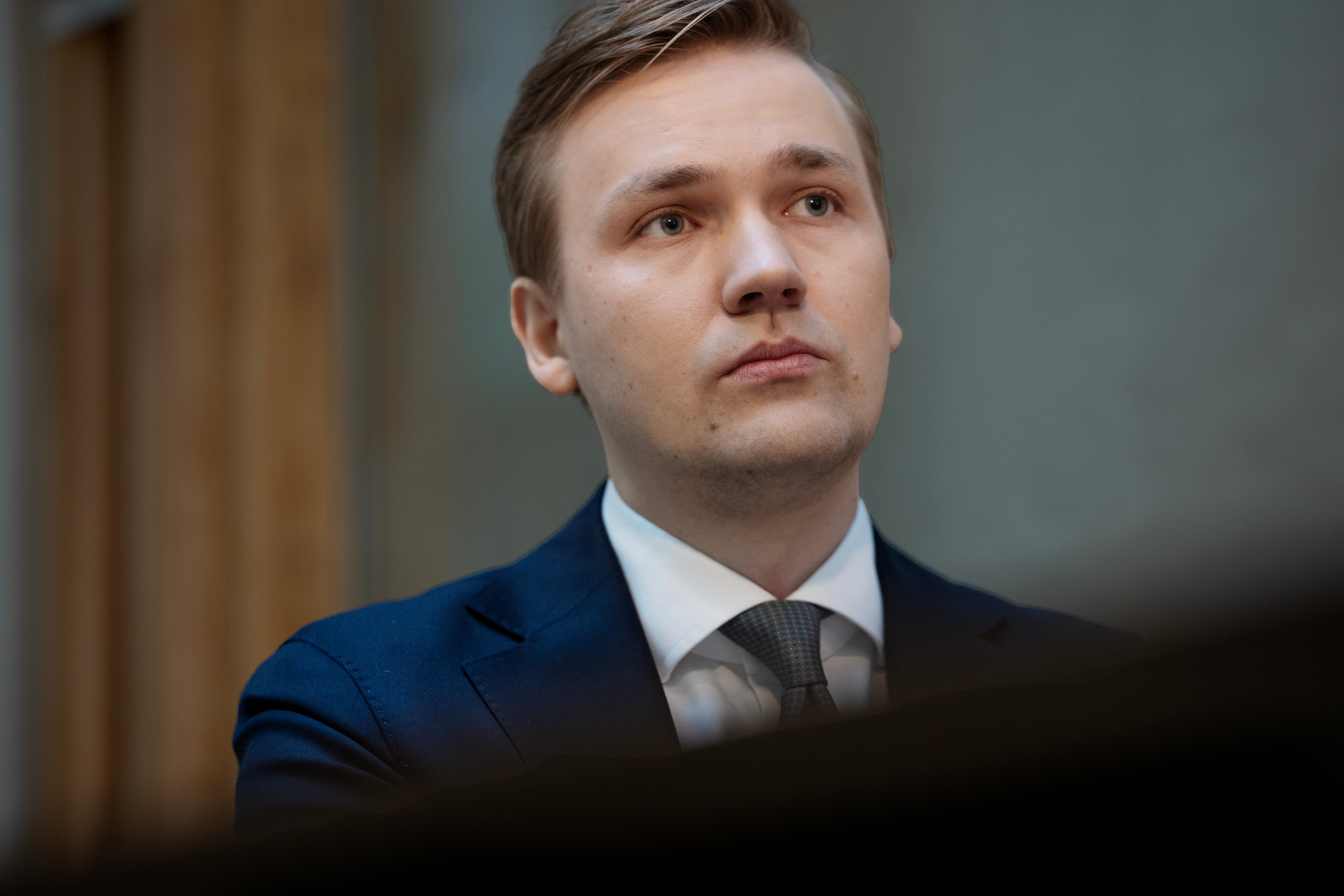 Porträtt av en man i mörkblå kostym och slips