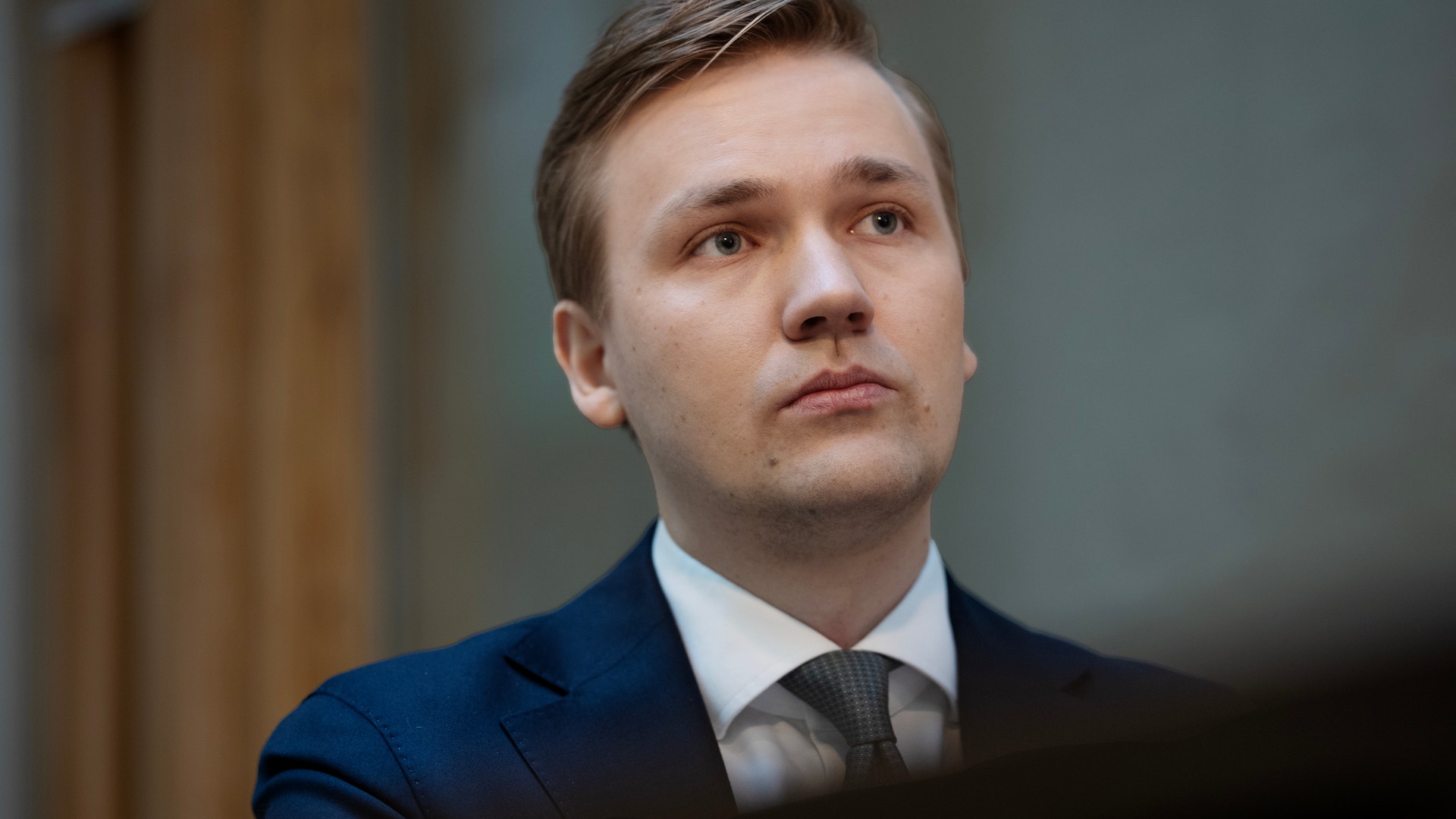 Porträtt av en man i mörkblå kostym och slips