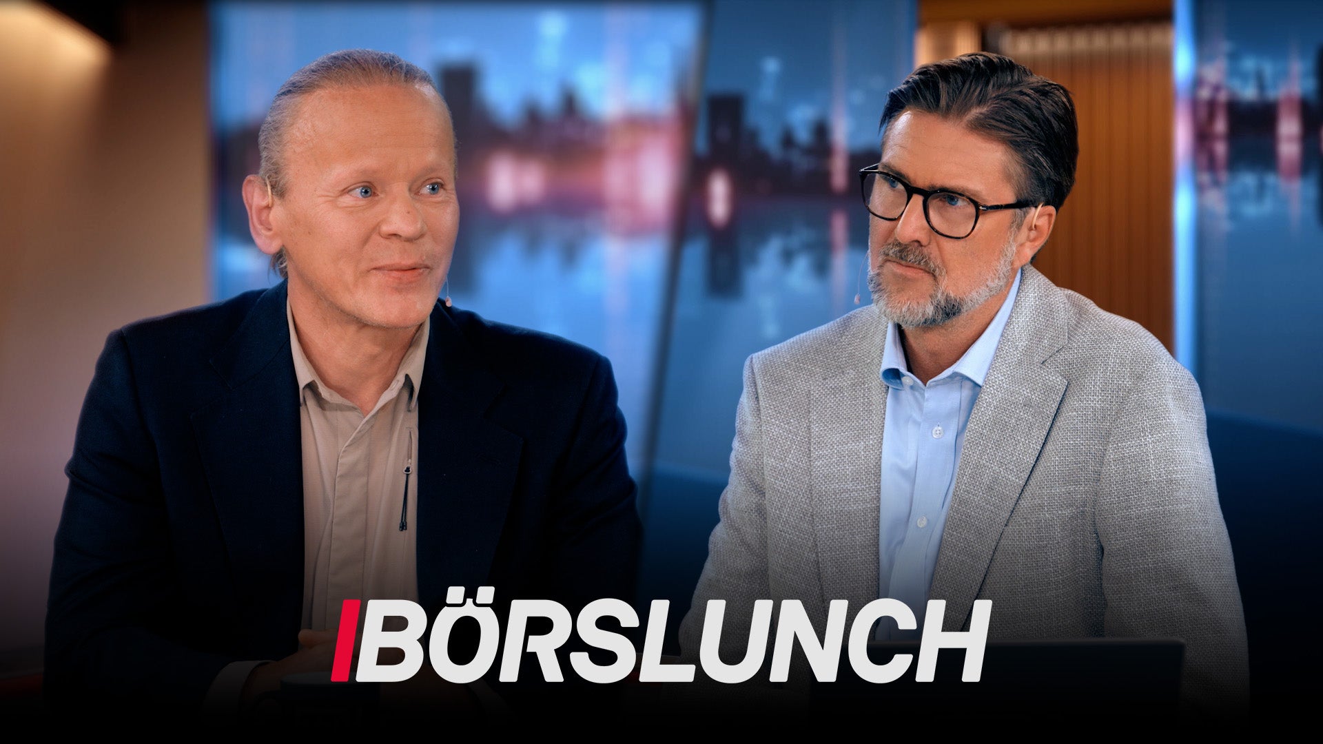 Två män i affärskläder sitter i ett TV-studio med stadshorisont i bakgrunden. Texten Börslunch visas längst ned på skärmen.