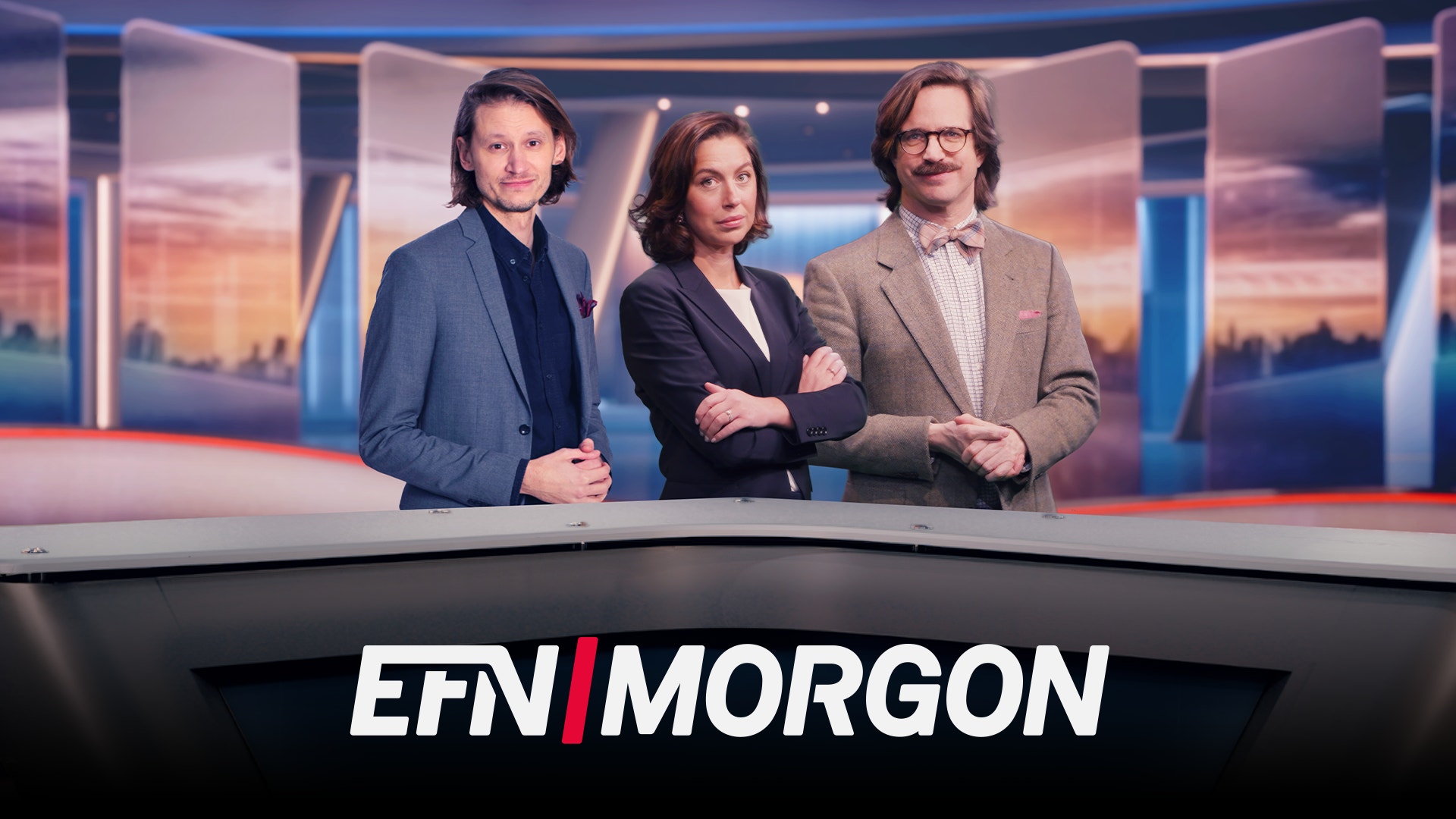 Tre nyhetspresentatörer står vid ett nyhetsbord i en TV-studio. I bakgrunden syns en stadshorisont vid solnedgång. Texten EFN MORGON visas längst ner på bilden.