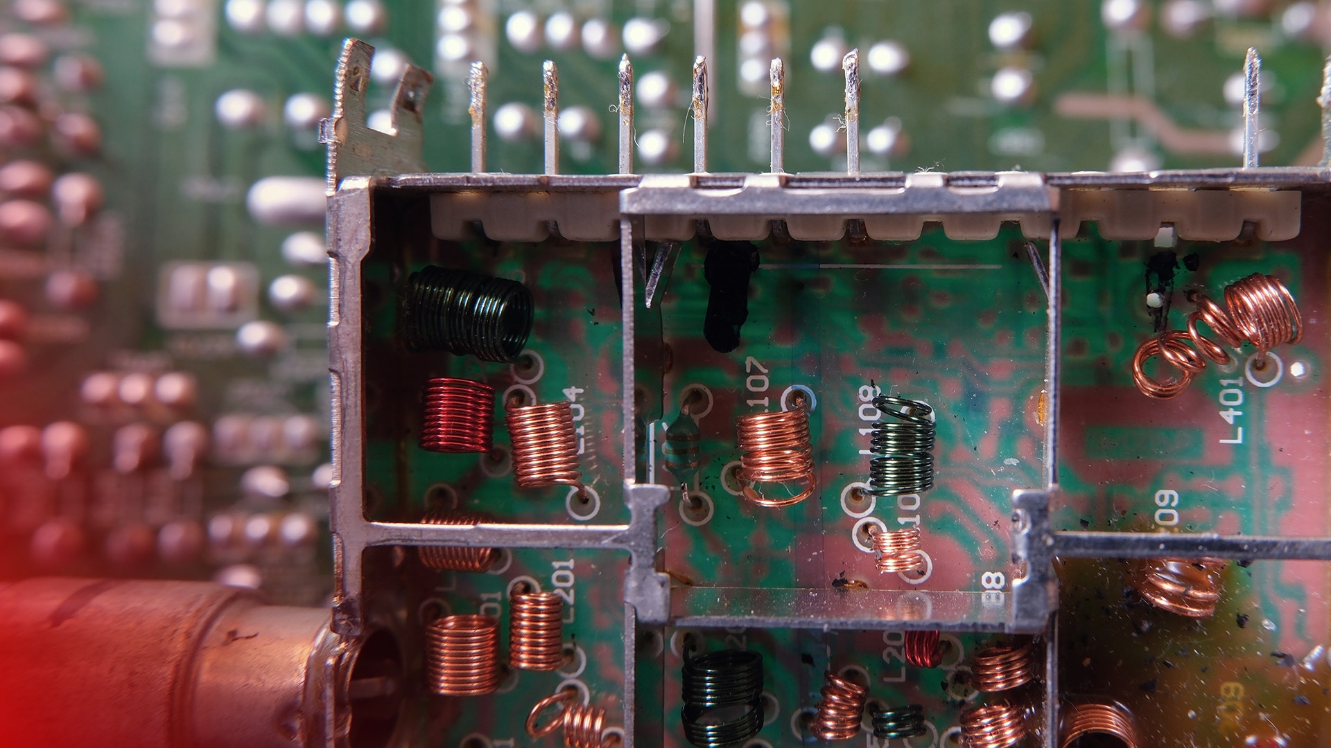 Närbild av elektronisk kretskort med kopparspolar och elektroniska komponenter