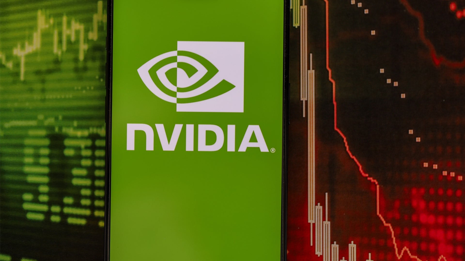 NVIDIA-logotyp på en smartphoneskärm med finansiella diagram i bakgrunden