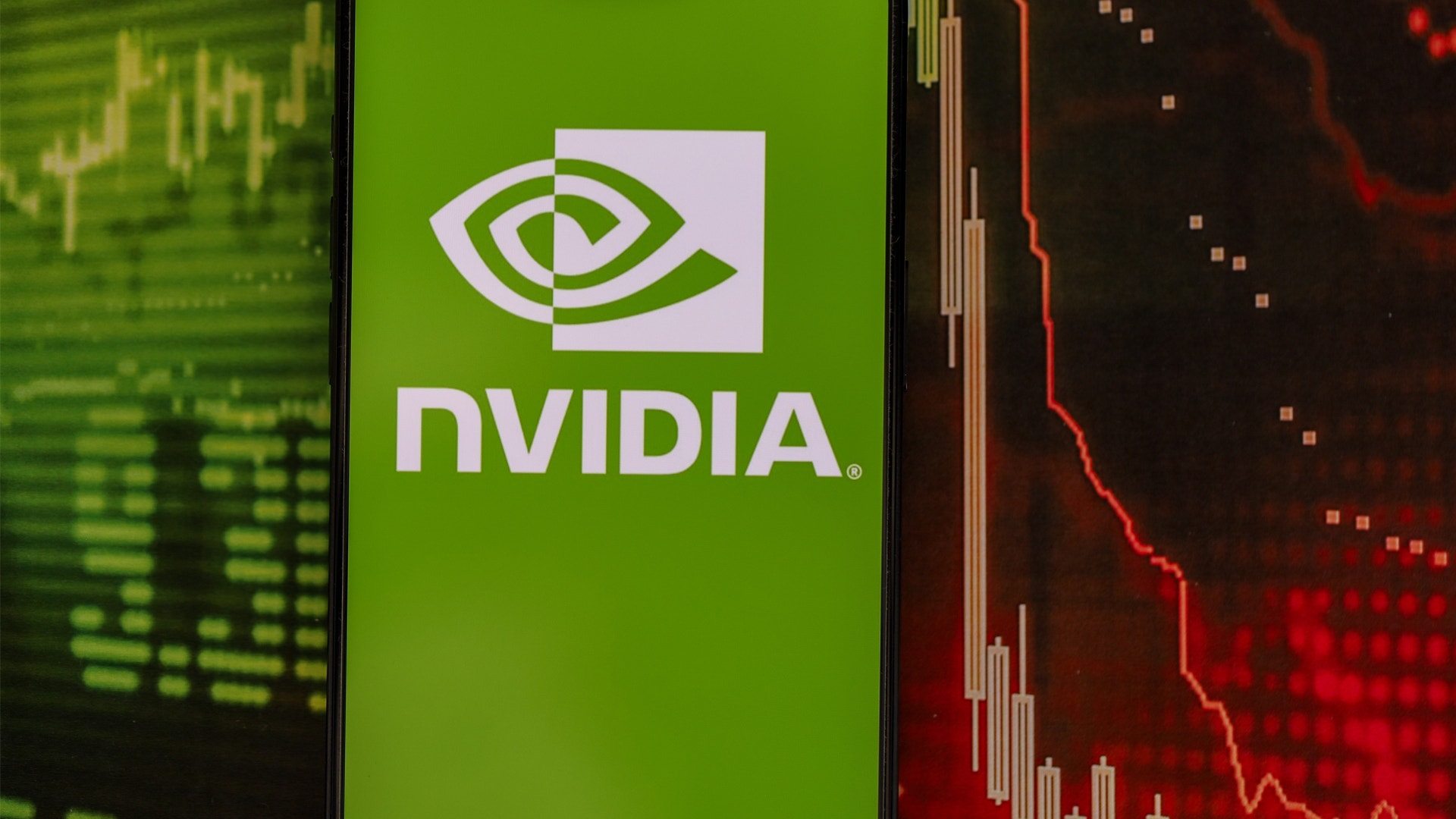 NVIDIA-logotyp på en smartphoneskärm med finansiella diagram i bakgrunden