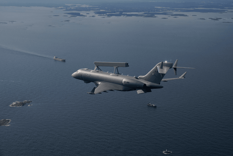 Militärt övervakningsflygplan flyger över havet med fartyg synliga under sig.