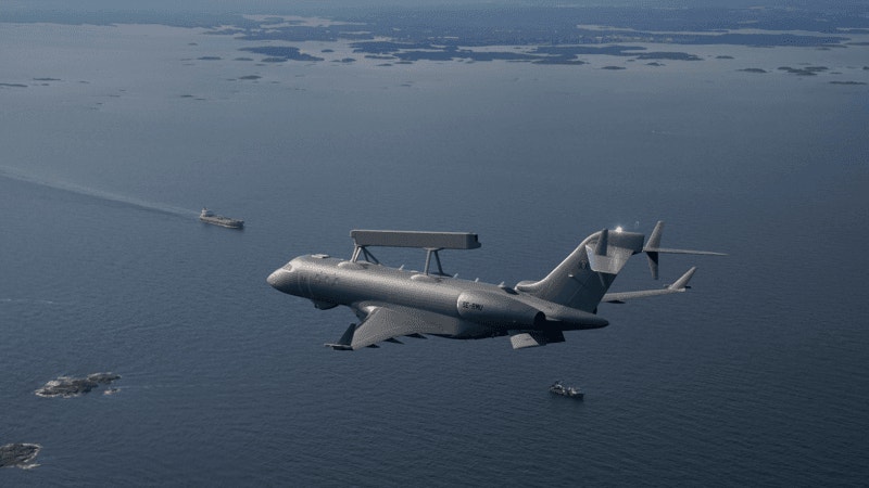 Militärt övervakningsflygplan flyger över havet med fartyg synliga under sig.