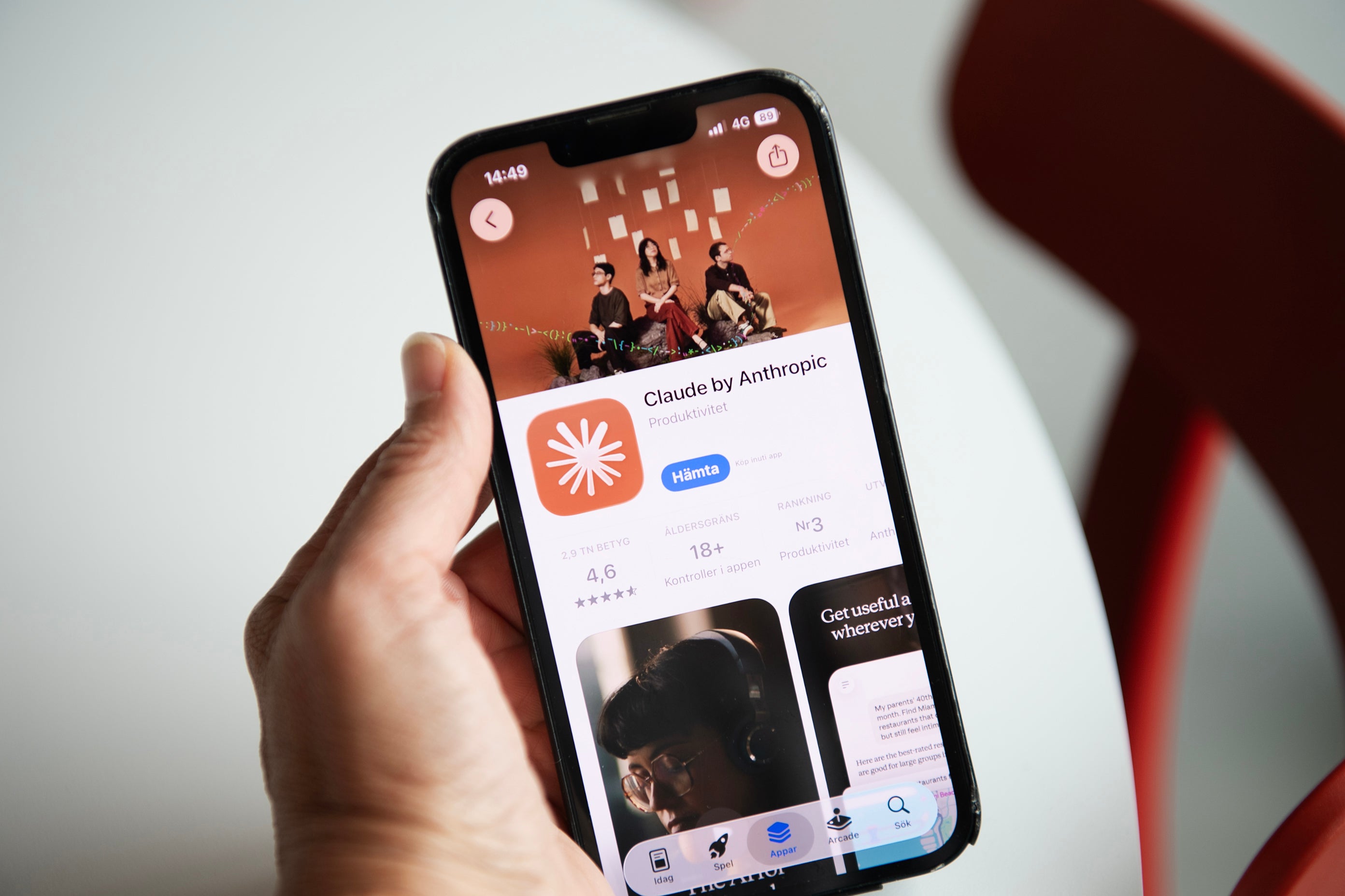 En hand håller en mobiltelefon som visar Anthropics app Claude i App Store.