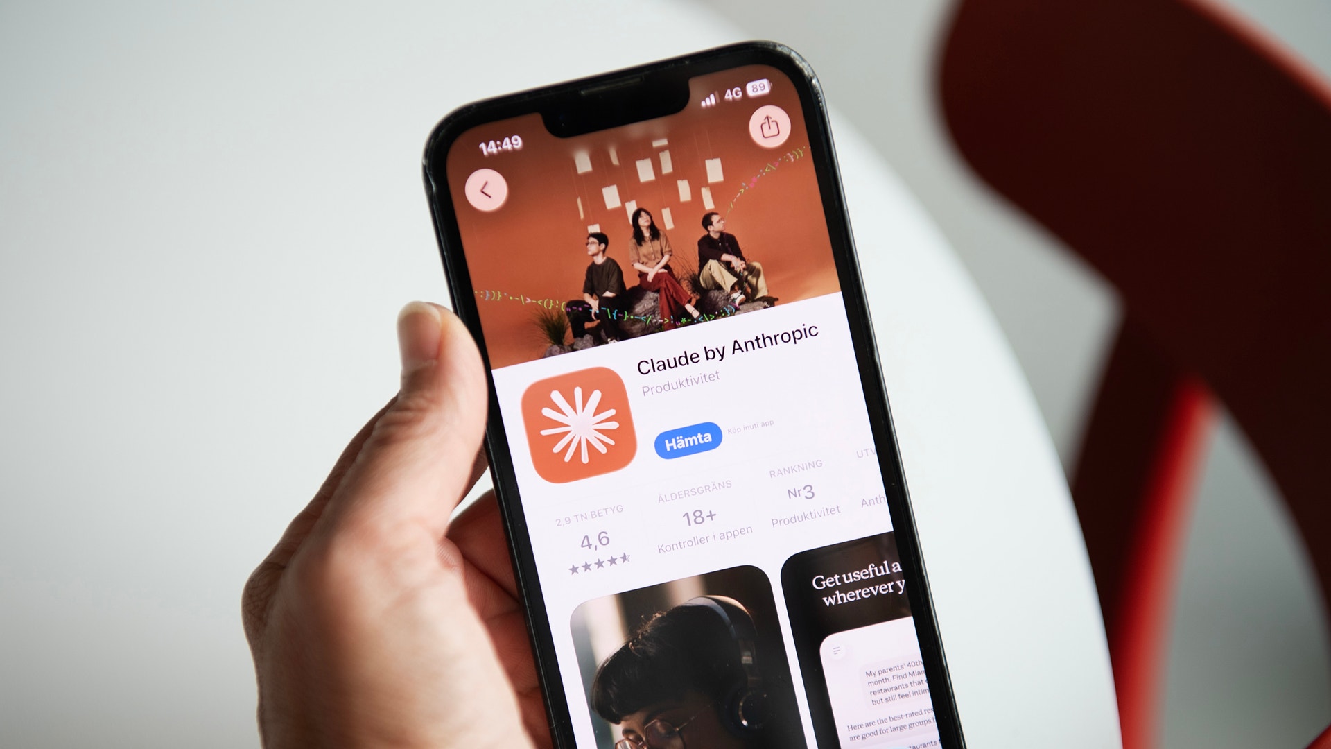 En hand håller en mobiltelefon som visar Anthropics app Claude i App Store.