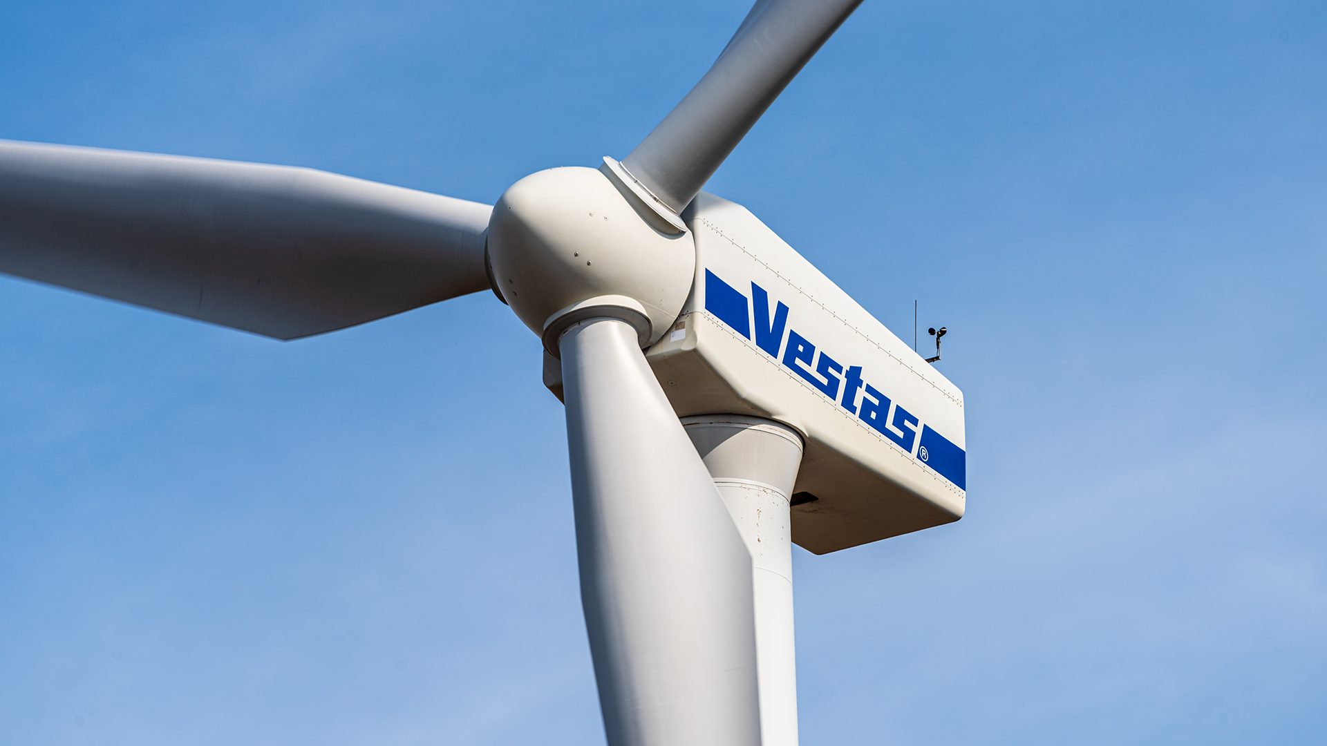 Närbild av en Vestas vindkraftturbin mot blå himmel