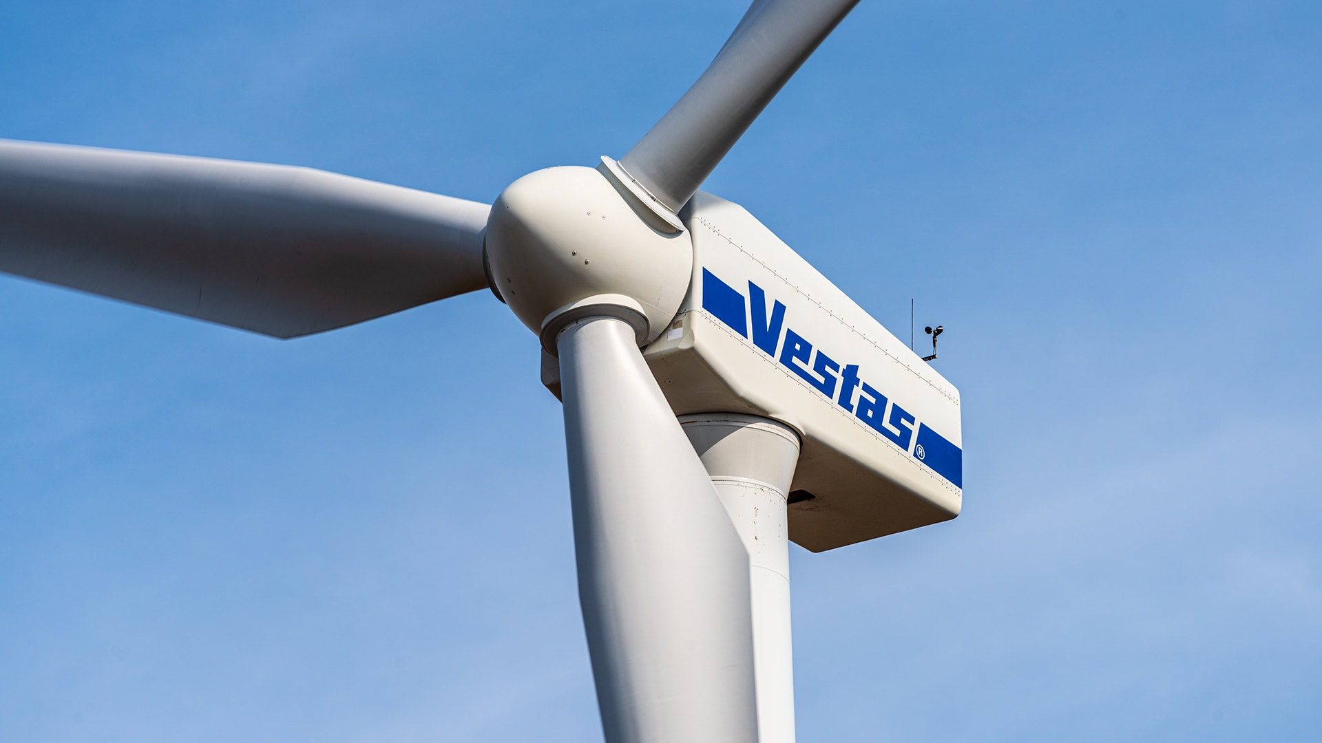 Närbild av en Vestas vindkraftturbin mot blå himmel