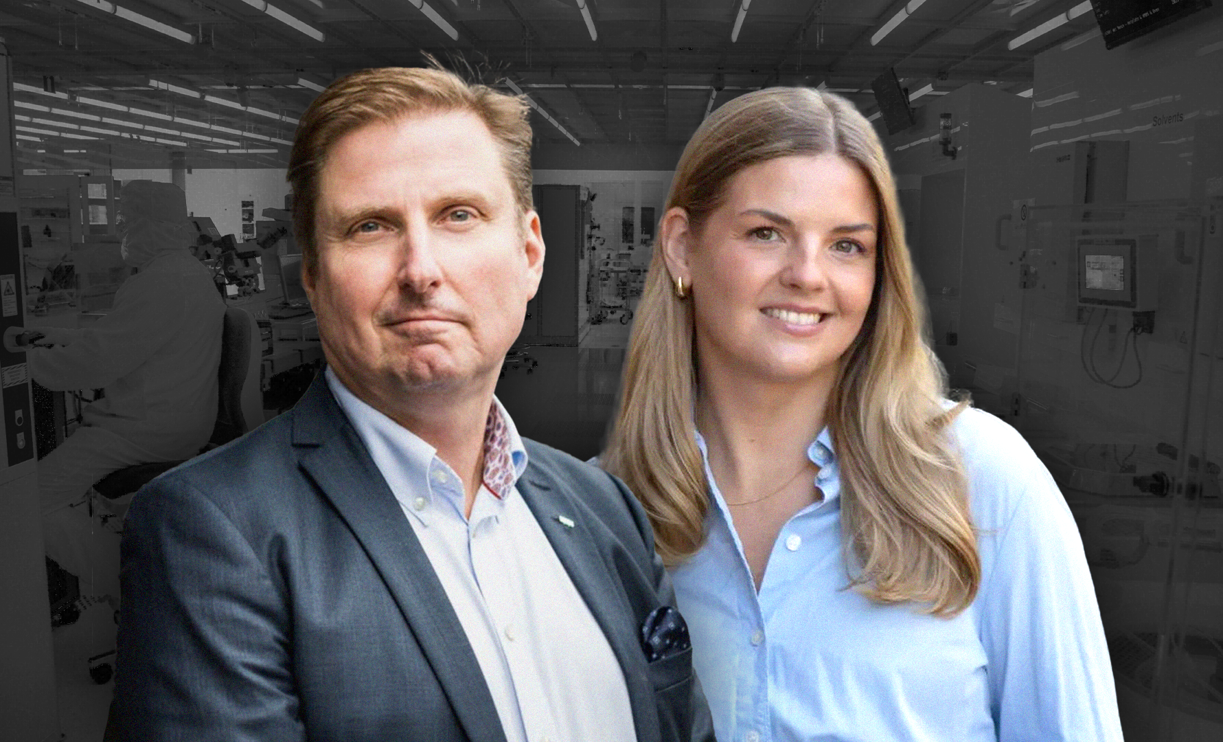 Två personer i professionell kläder poserar tillsammans framför en industriell bakgrund.