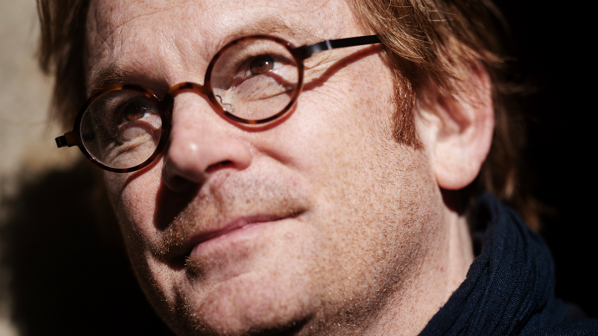 Porträtt av en man med glasögon som tittar mot sidan.