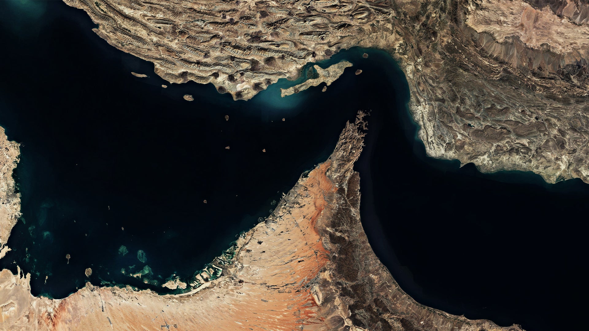 Satellitbild av Persiska golfen med omgivande ökenlandskap. Mörkt blått vatten omgivet av beige och brunt färgad mark.