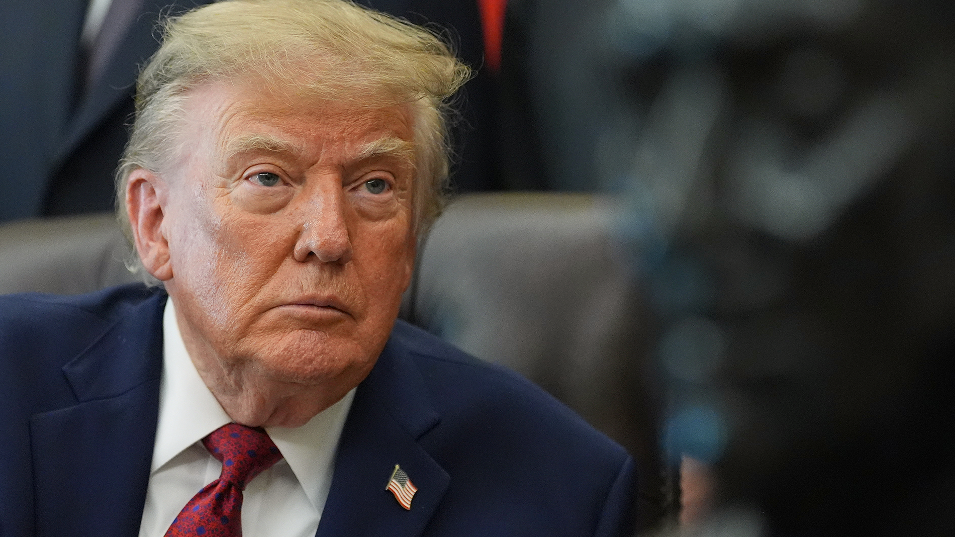 Donald Trump i kostym och slips med allvarlig min.