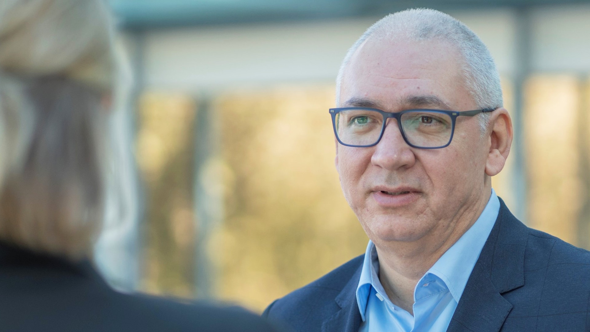 Porträtt av en man med glasögon och blå skjorta