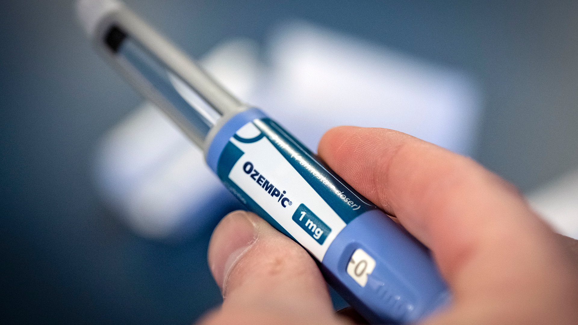 En hand håller en injektionspenna med texten Ozempic 1 mg.