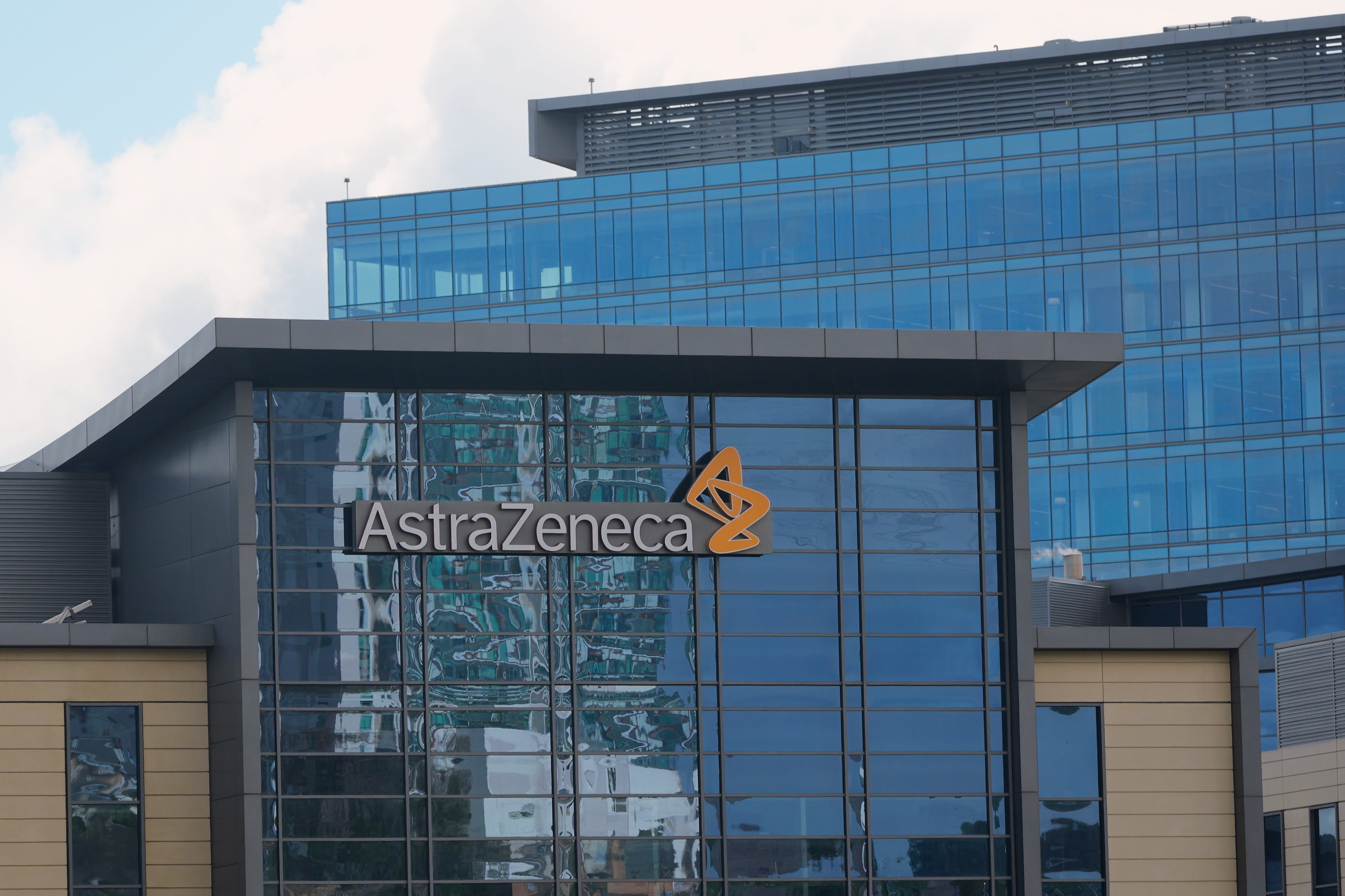 Modernt kontorsbyggnad med AstraZenecas logotyp och namn på fasaden. Byggnaden har stora glasfönster och blå färgschema.