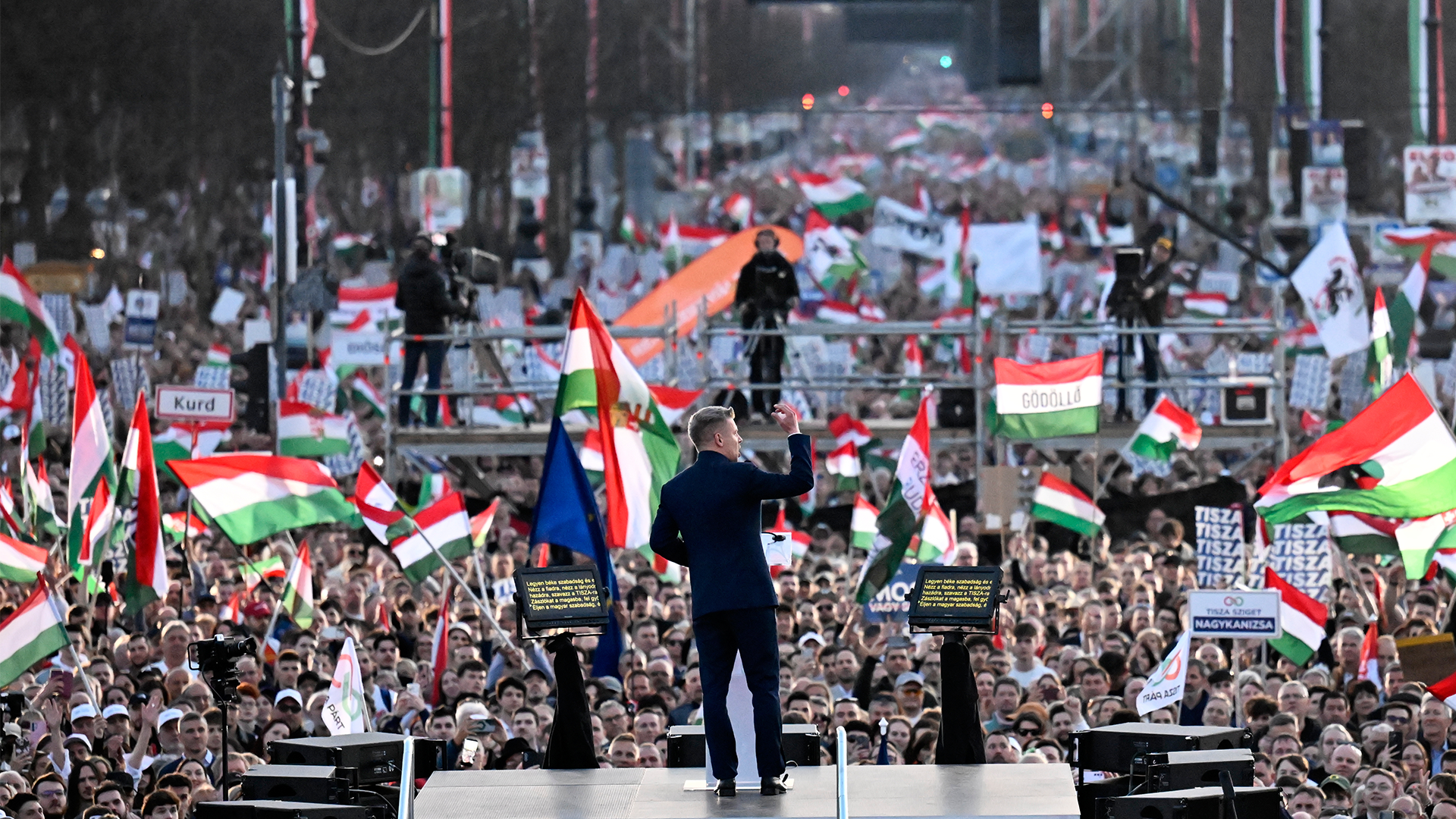 En stor folksamling med människor som håller upp ungerska flaggor under ett offentligt evenemang.
