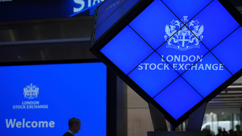 Utomhusfoto av Londonbörsen med blåupplyst skyltning och LSE-logotyp på byggnadsfasaden.