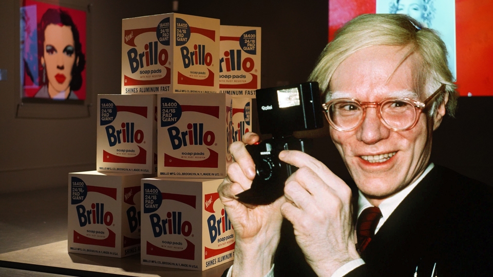 En pyramid av Brillo Boxar och ett utklipp av konstnären Andy Warhol som håller en kamera.