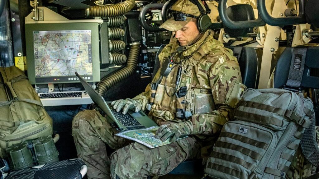 En militär sitter i utrustning från försvarsbolaget Mildef.