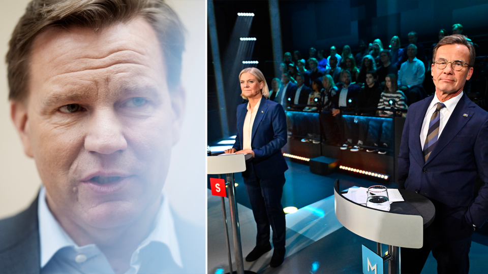 En man i kostym talar, i bakgrunden syns två partiledare i debatt inför publik.